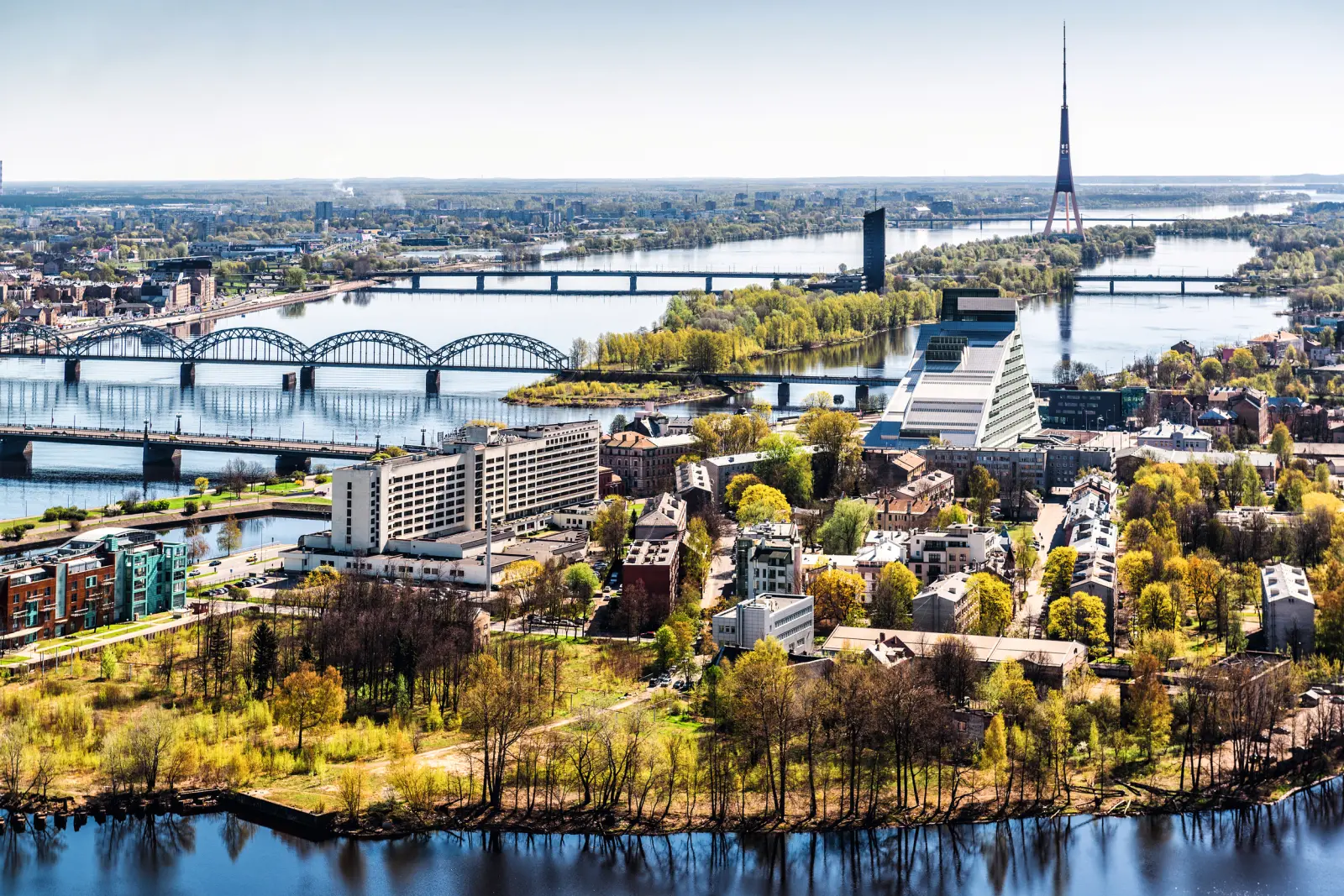City view with river, bridge, buildings and a television tower in the background.