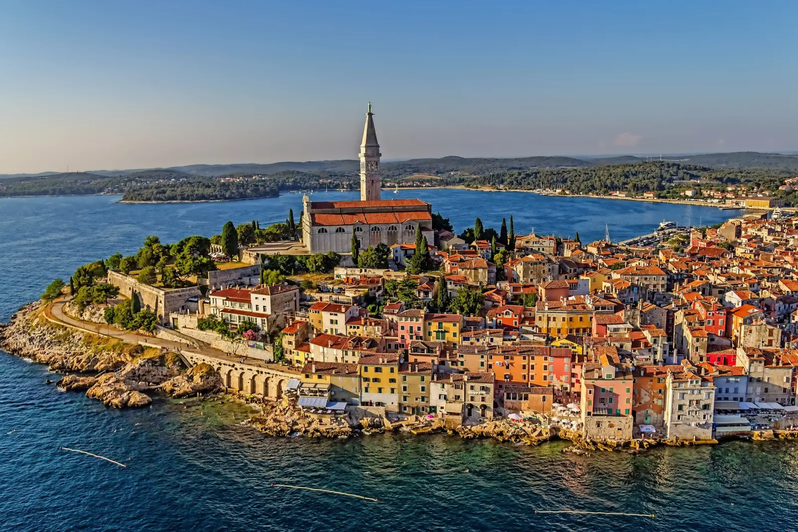 Küstenstadt mit alter Kirche und bunten Häusern am Meer.