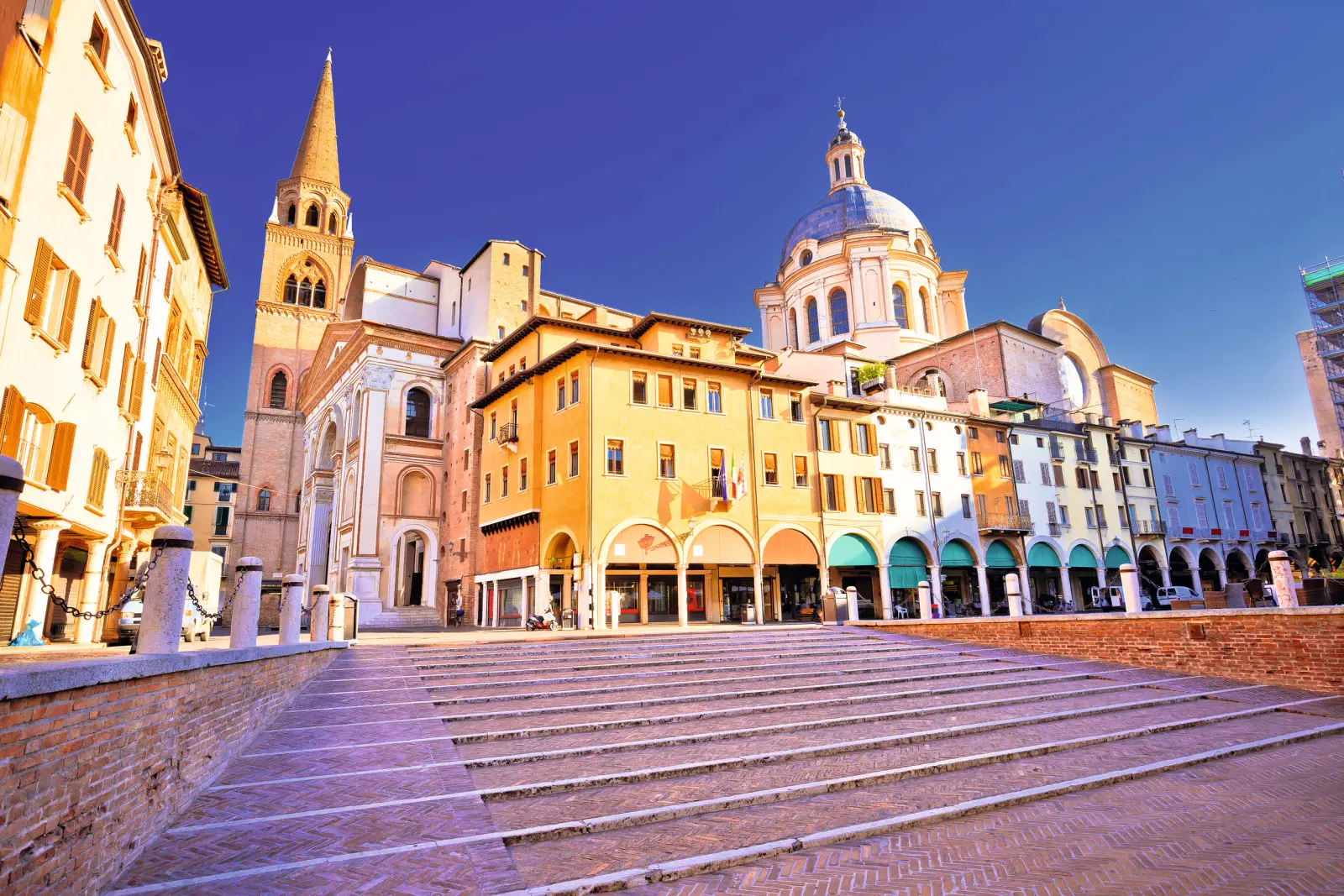 Edifici storici e chiesa su una piazza con scalinate.