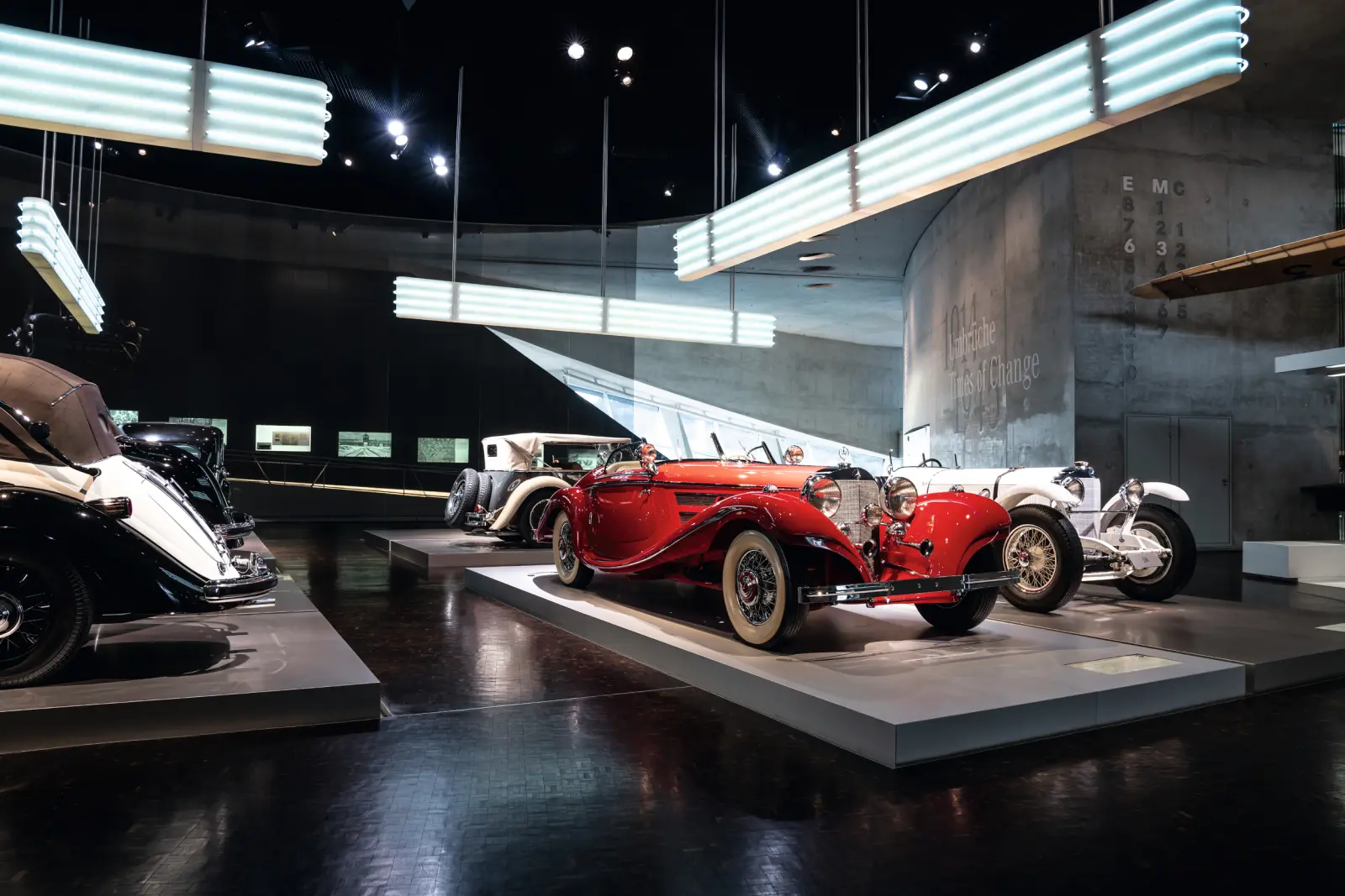 Klassische Autos in einem Ausstellungsraum, rostrote Modelle im Vordergrund.