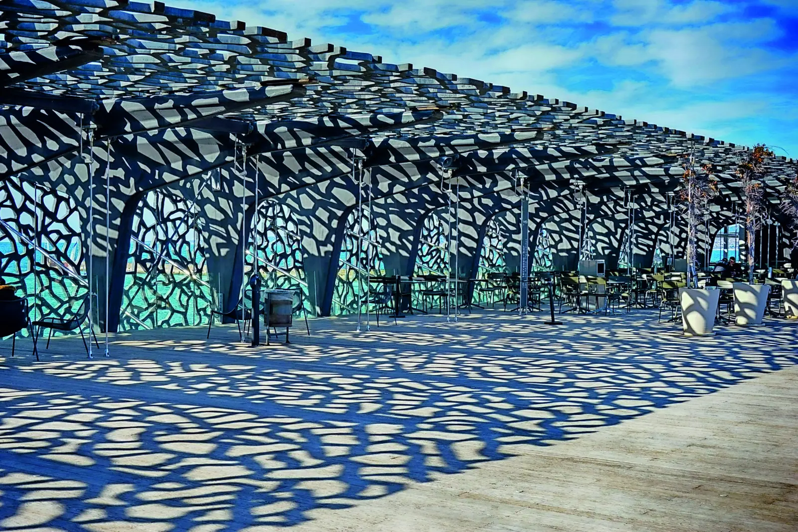 Covered terrace with intricate shadow patterns in the sunshine.