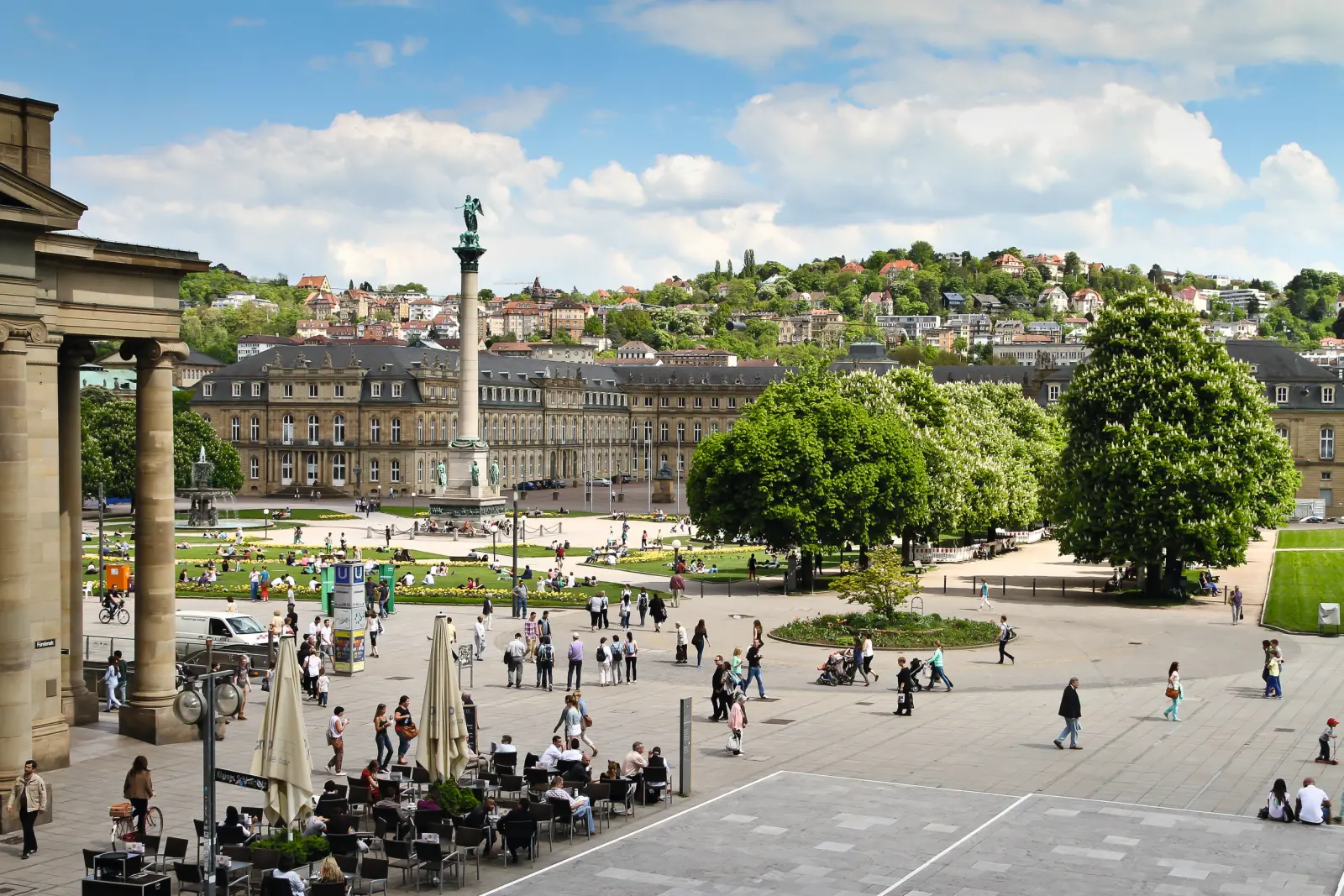 Menschen im Schlossplatz von Stuttgart an einem sonnigen Tag.