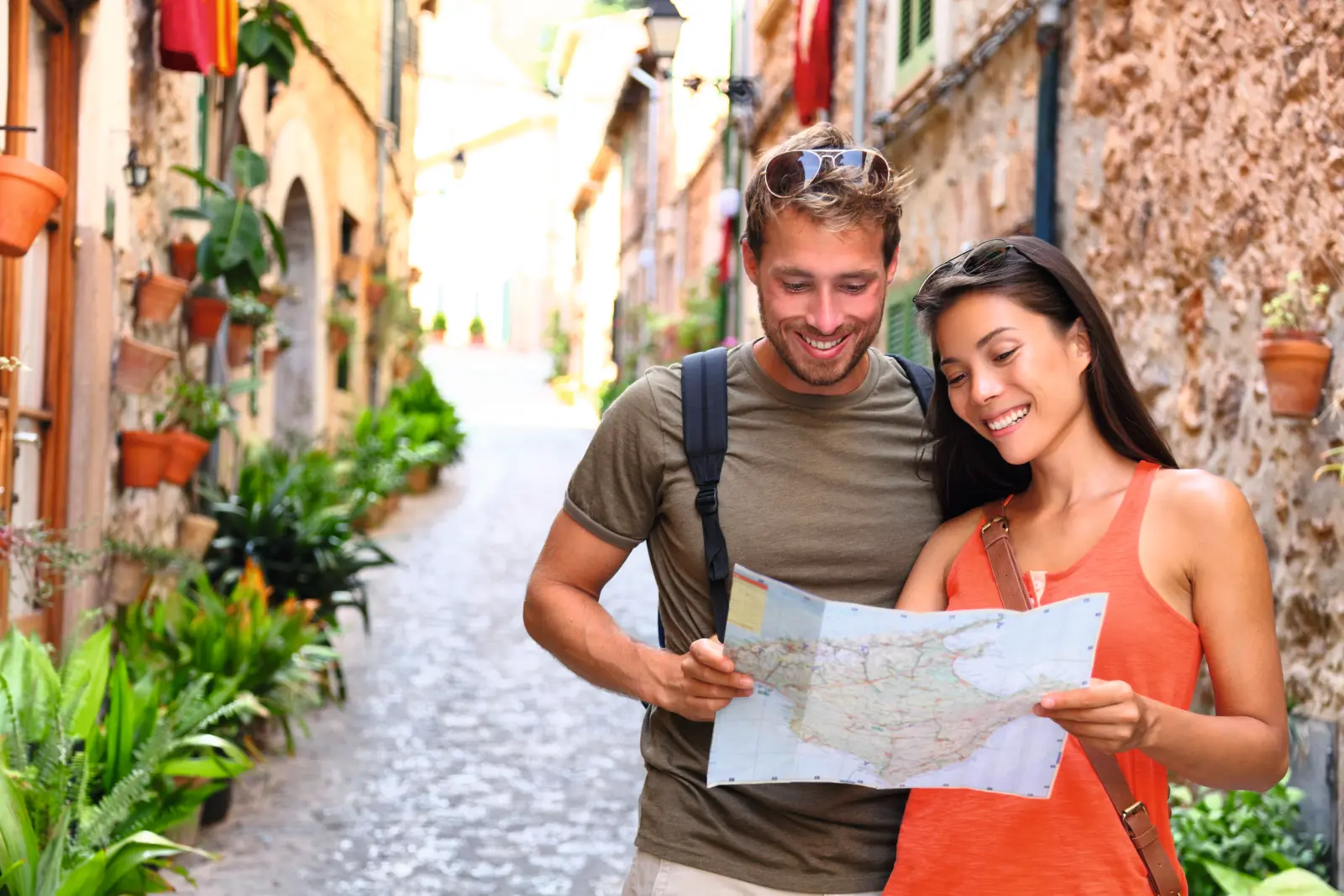Two people looking at a map in a cobbled lane.