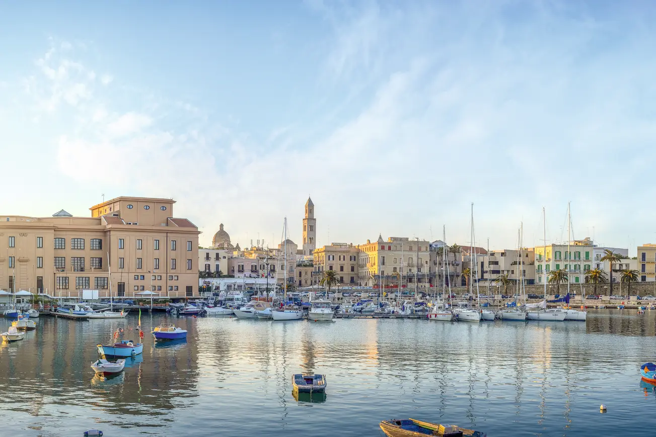 Harbour town at sunrise with boats and buildings by the water.