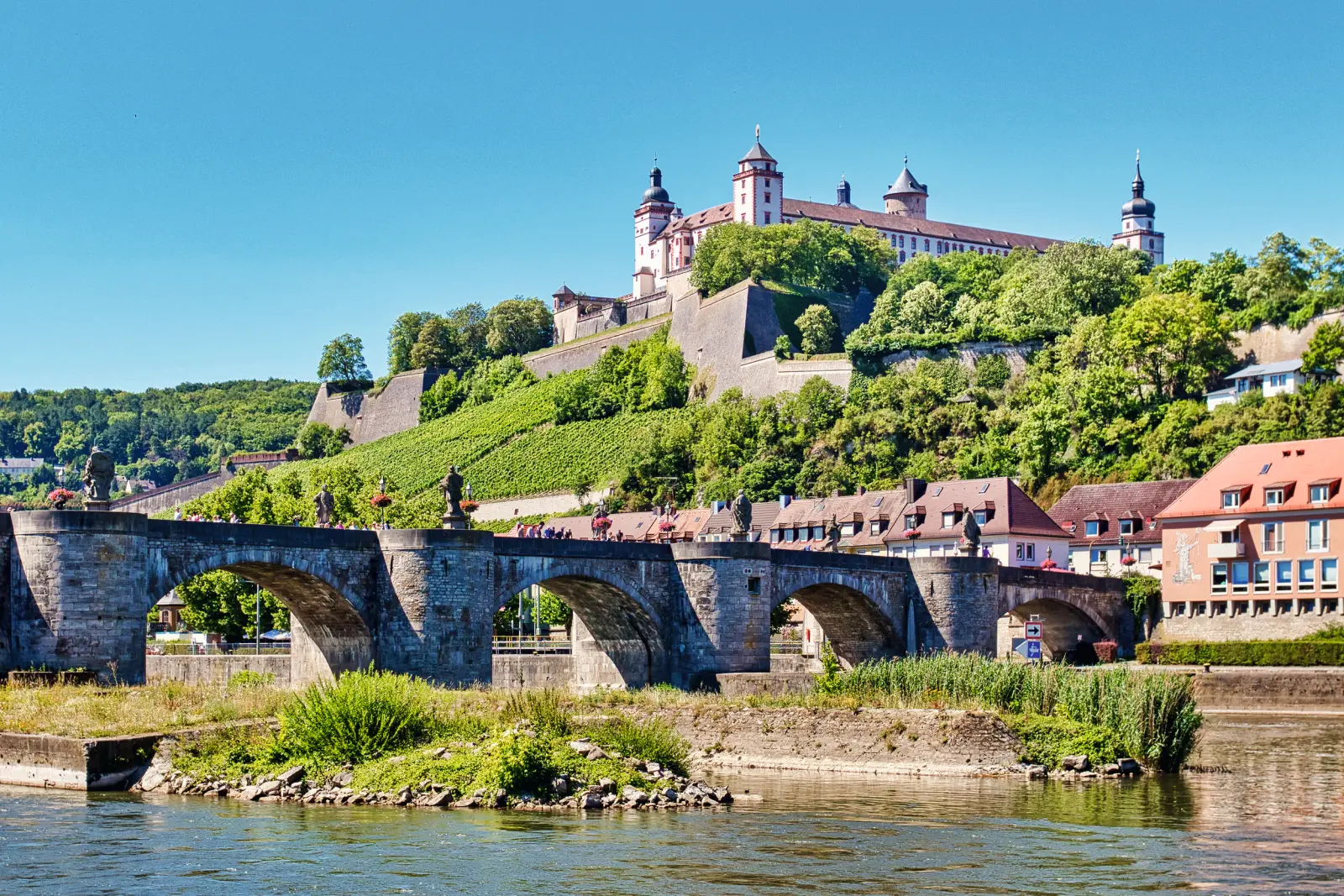 Castello su una collina sopra un ponte e un fiume in una giornata di sole