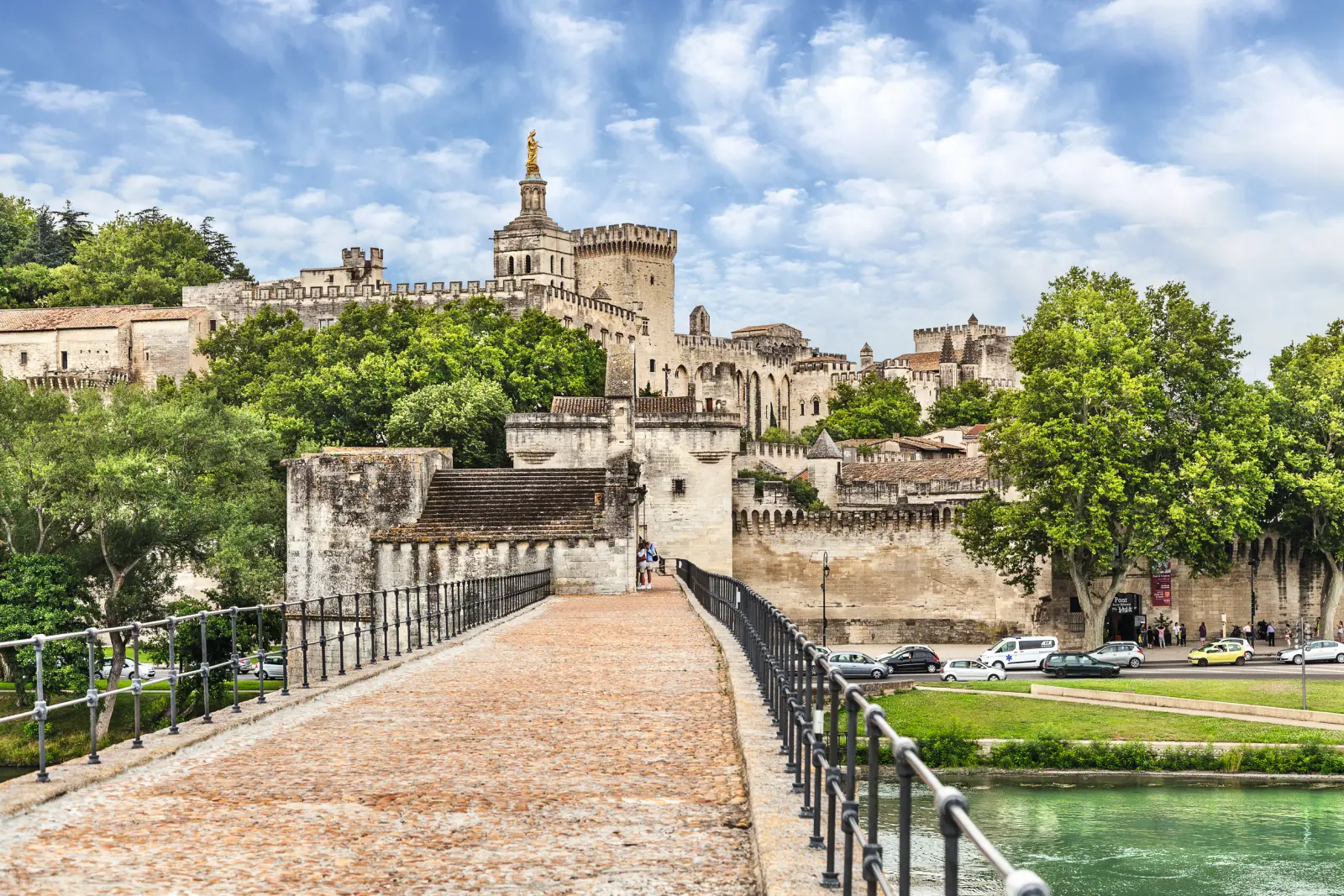 Bridge in Avignon with an old building in the background on a sunny day.