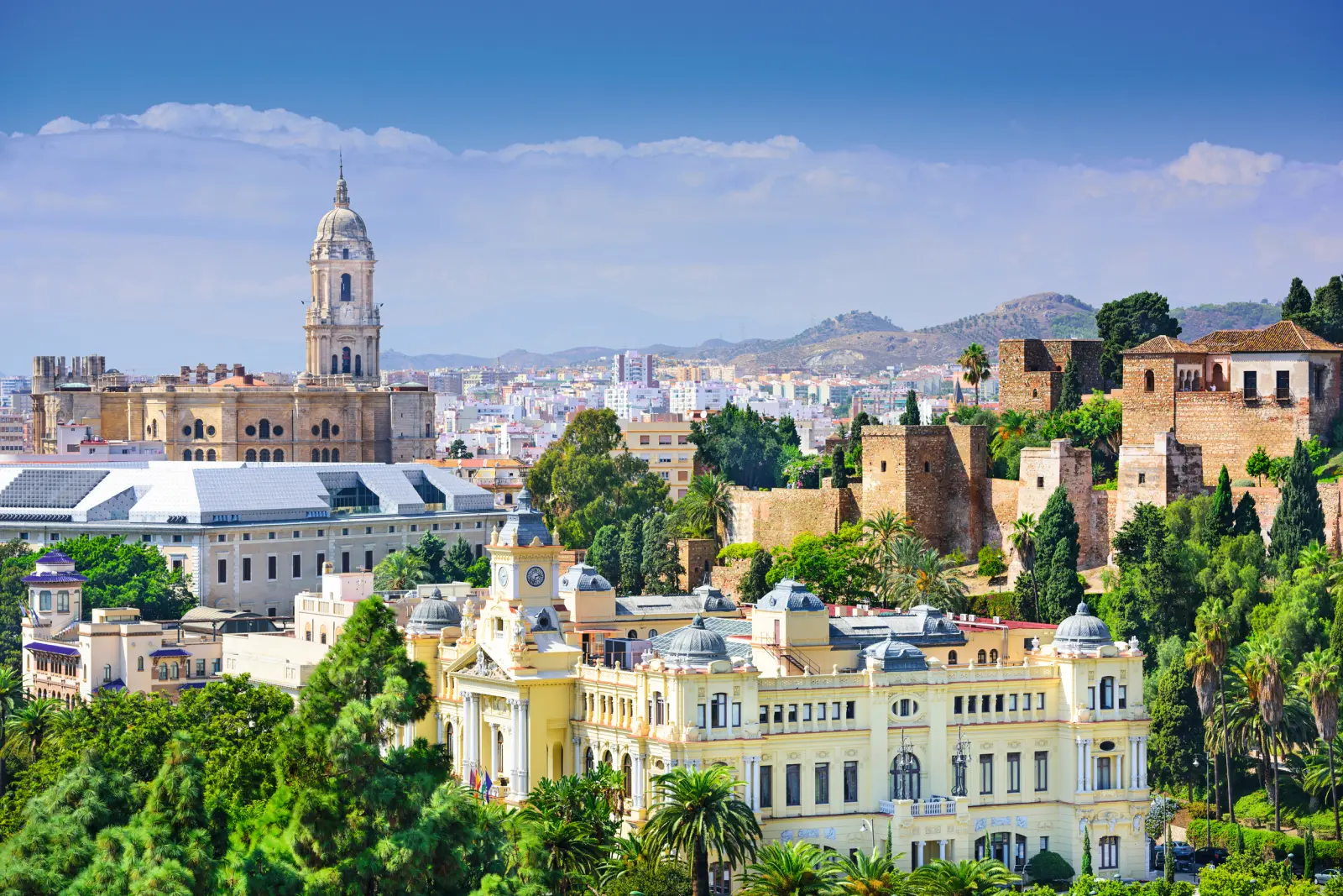 Vista su edifici storici a Malaga, Spagna, circondati da colline e vegetazione.
