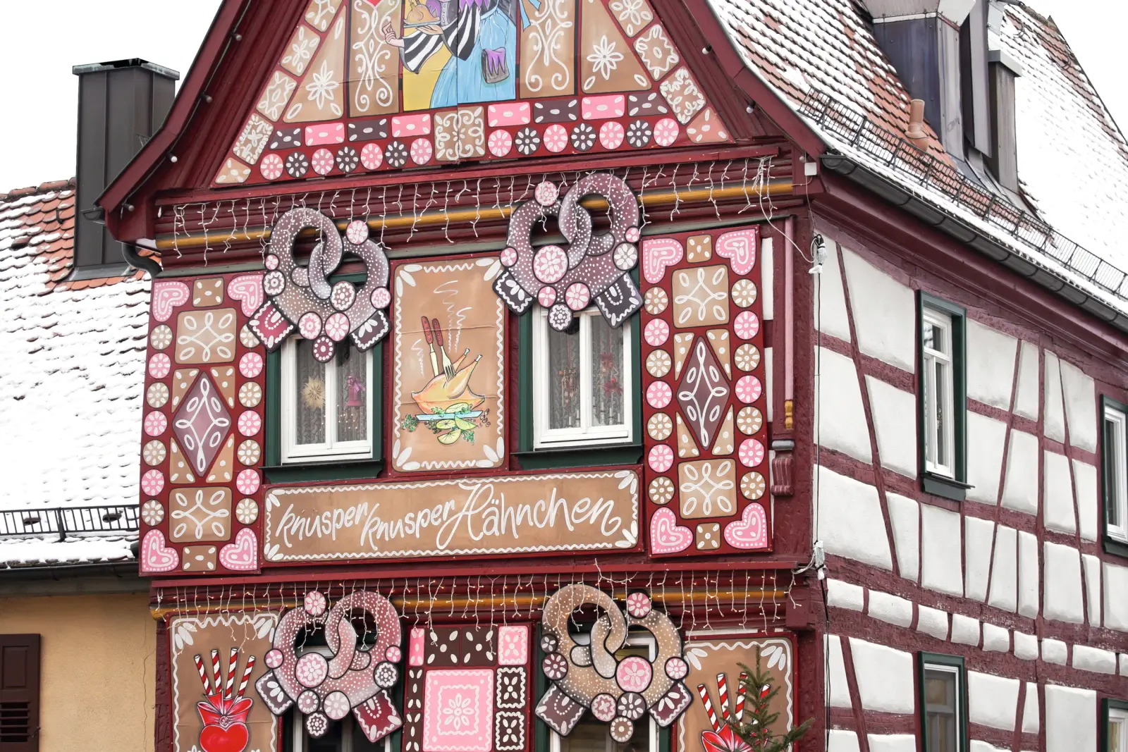 Maison à colombages décorée façon pain d’épices, avec un paysage hivernal à l’arrière-plan.