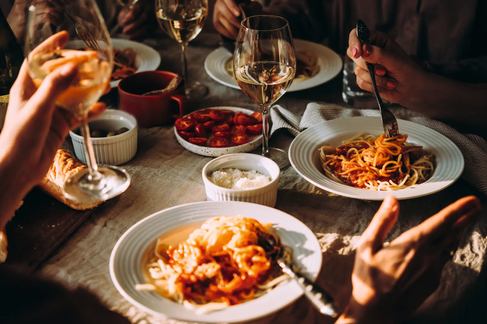 Des personnes mangent des pâtes lors d’un dîner convivial.