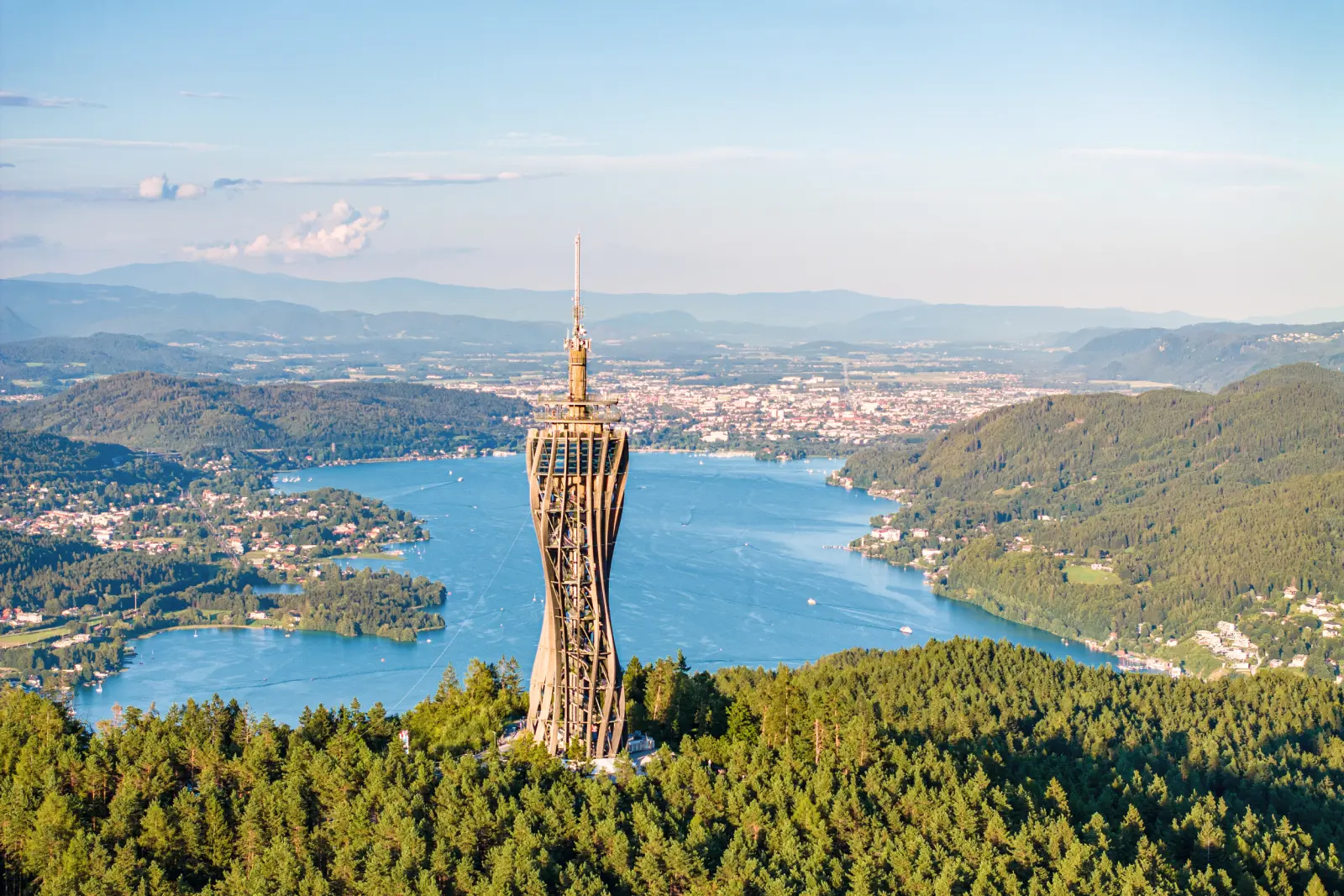 Vista dal Pyramidenkogel sul Wörthersee in Carinzia, circondato da boschi e montagne.