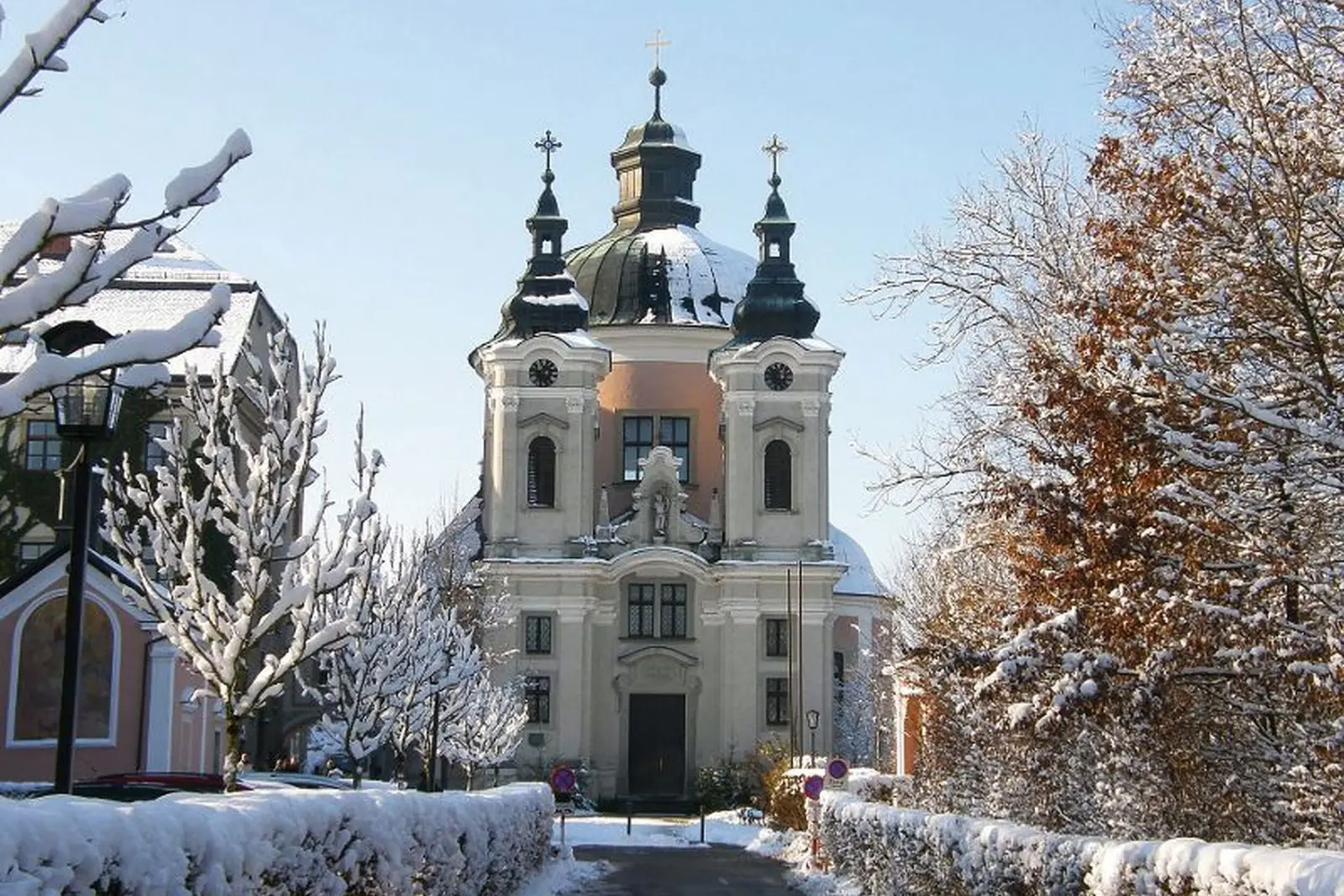 Église de pèlerinage de Christkindl en hiver, avec de la neige sur les arbres et les chemins.