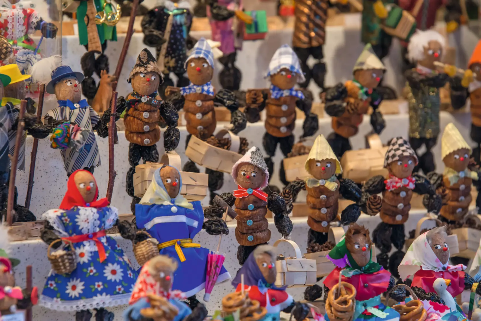 Various figures made from chestnuts and other materials on a market stall.
