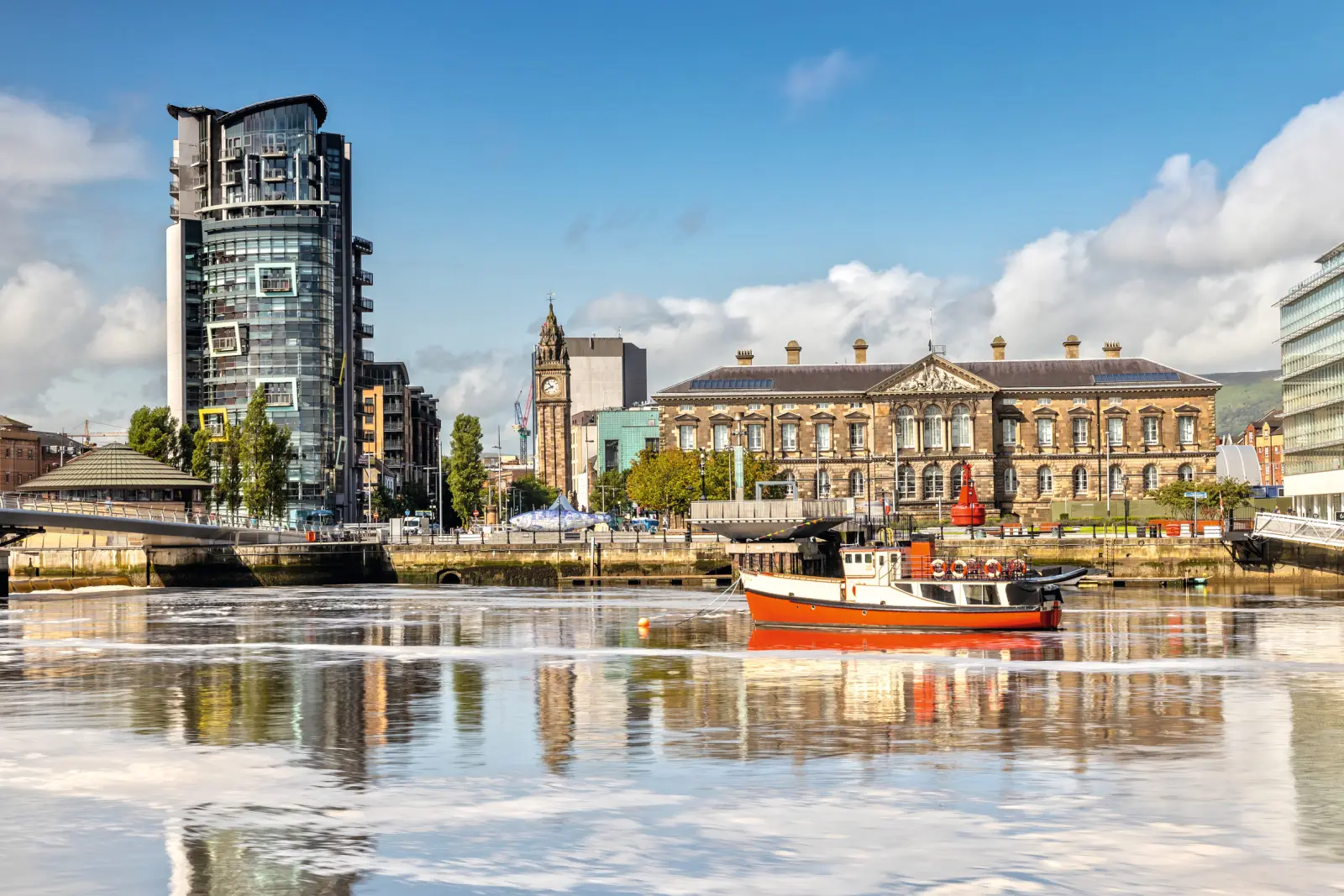 River landscape with modern buildings and a boat in the foreground on a sunny day