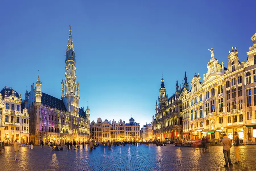 Grand Place in Brüssel bei Sonnenuntergang mit historischer Architektur und lebendiger Atmosphäre.