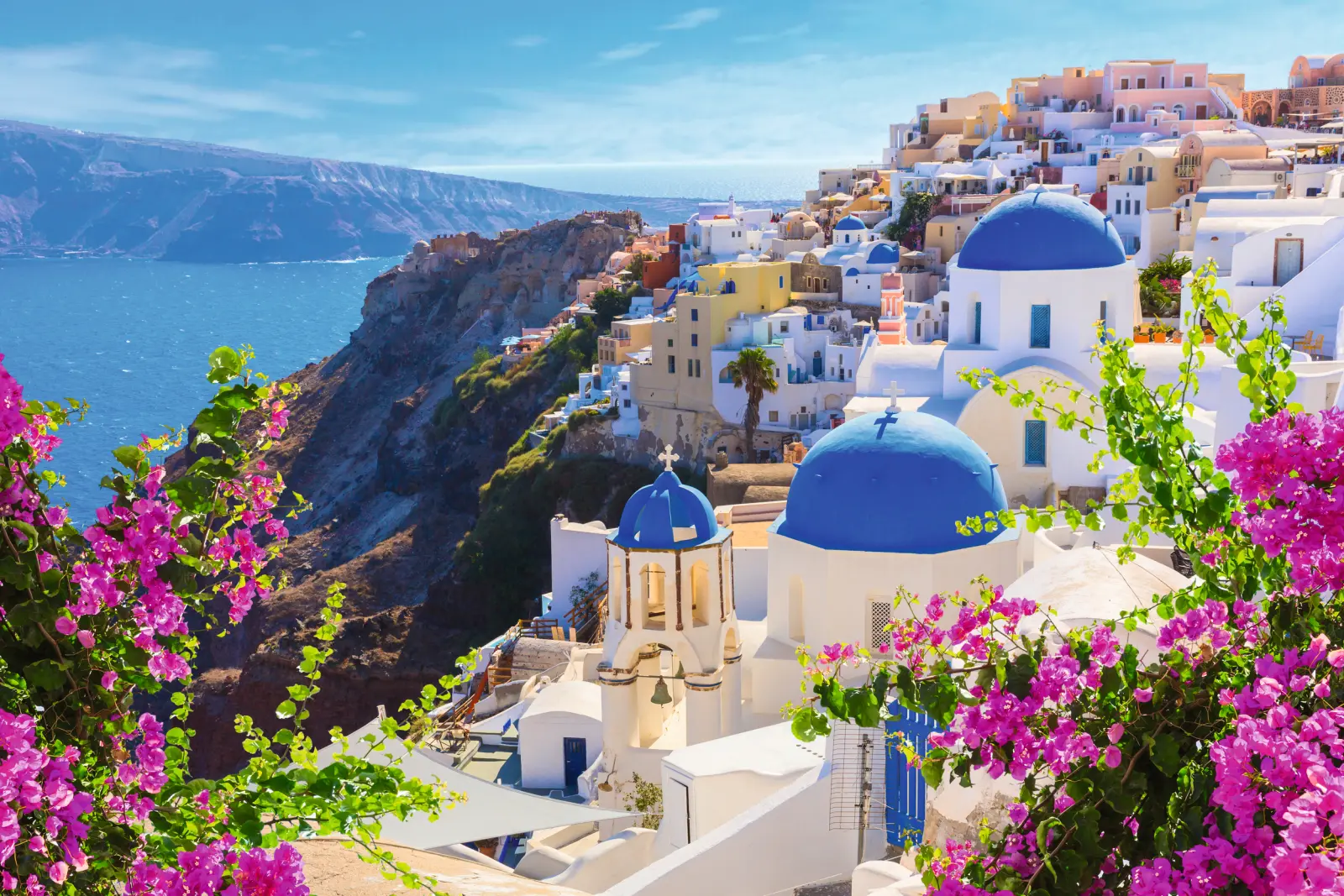 Villaggio greco con cupole blu e vista sul mare.