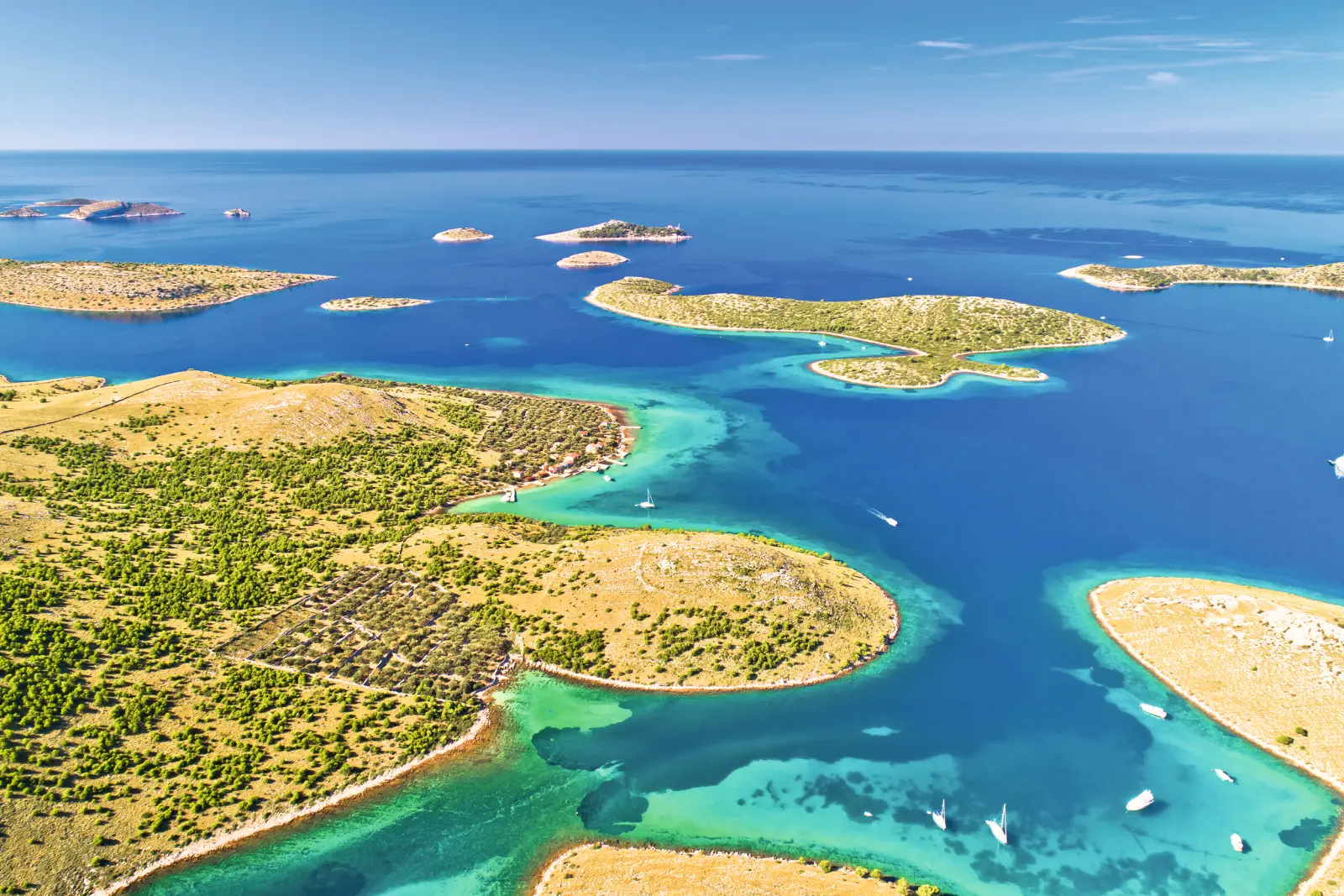 Luftaufnahme von Inseln und klarem blauem Meer mit Booten.