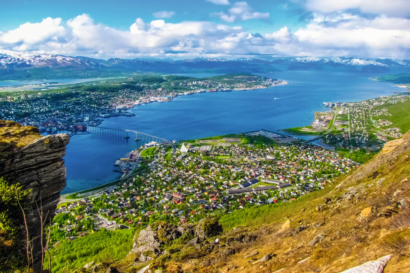 Aerial view of a coastal city with a bridge and water in the background