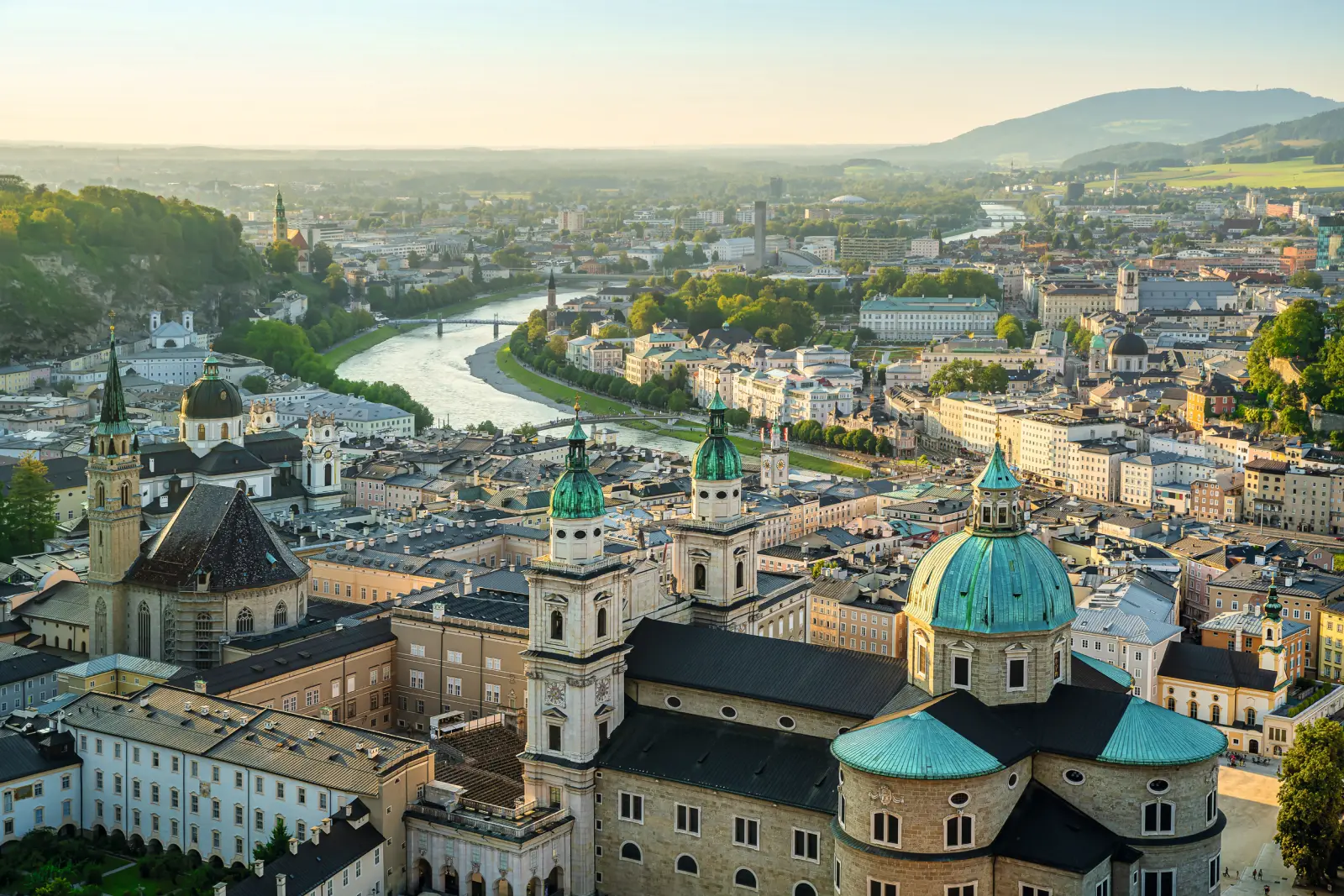 Veduta della città di Salisburgo con il fiume e gli edifici storici alla luce della sera.