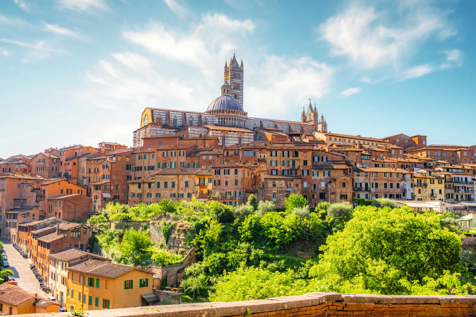 Paesaggio urbano storico con una cattedrale sullo sfondo sotto un cielo azzurro.