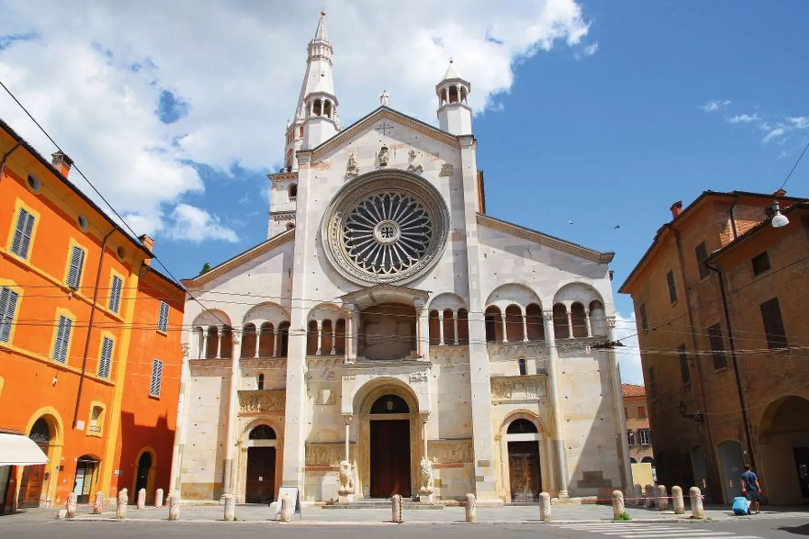 Cattedrale di Modena con rosone e torri sotto un cielo azzurro.