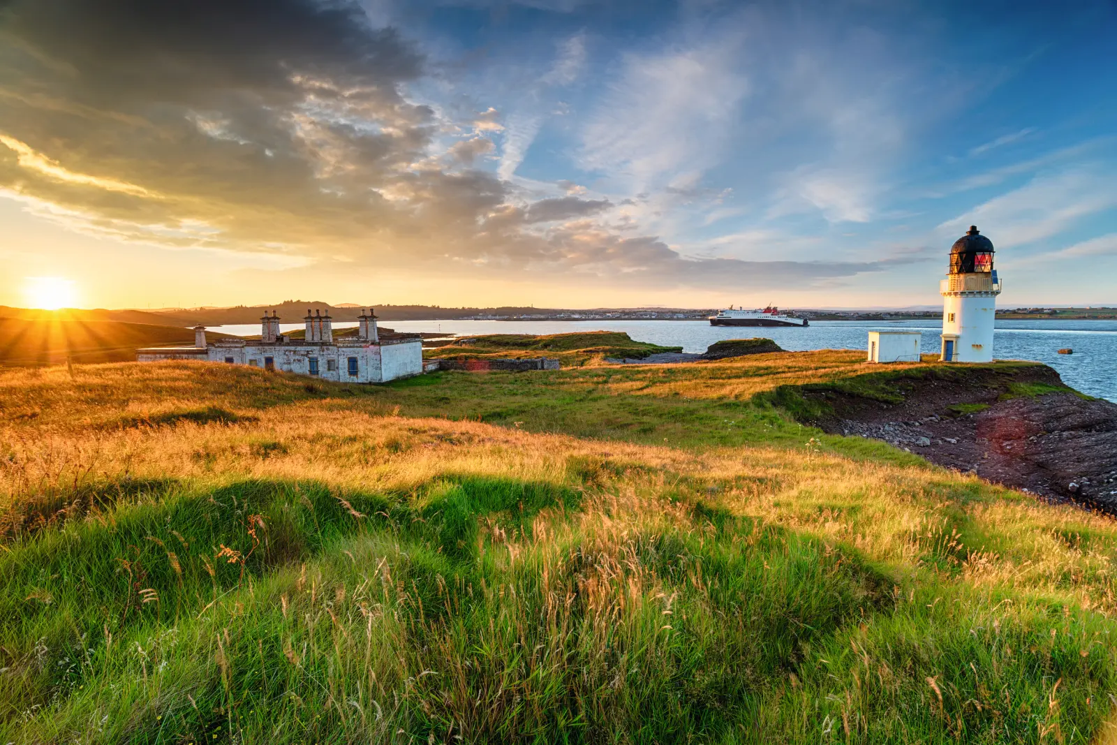 Landscape with a lighthouse and the sea at sunset.