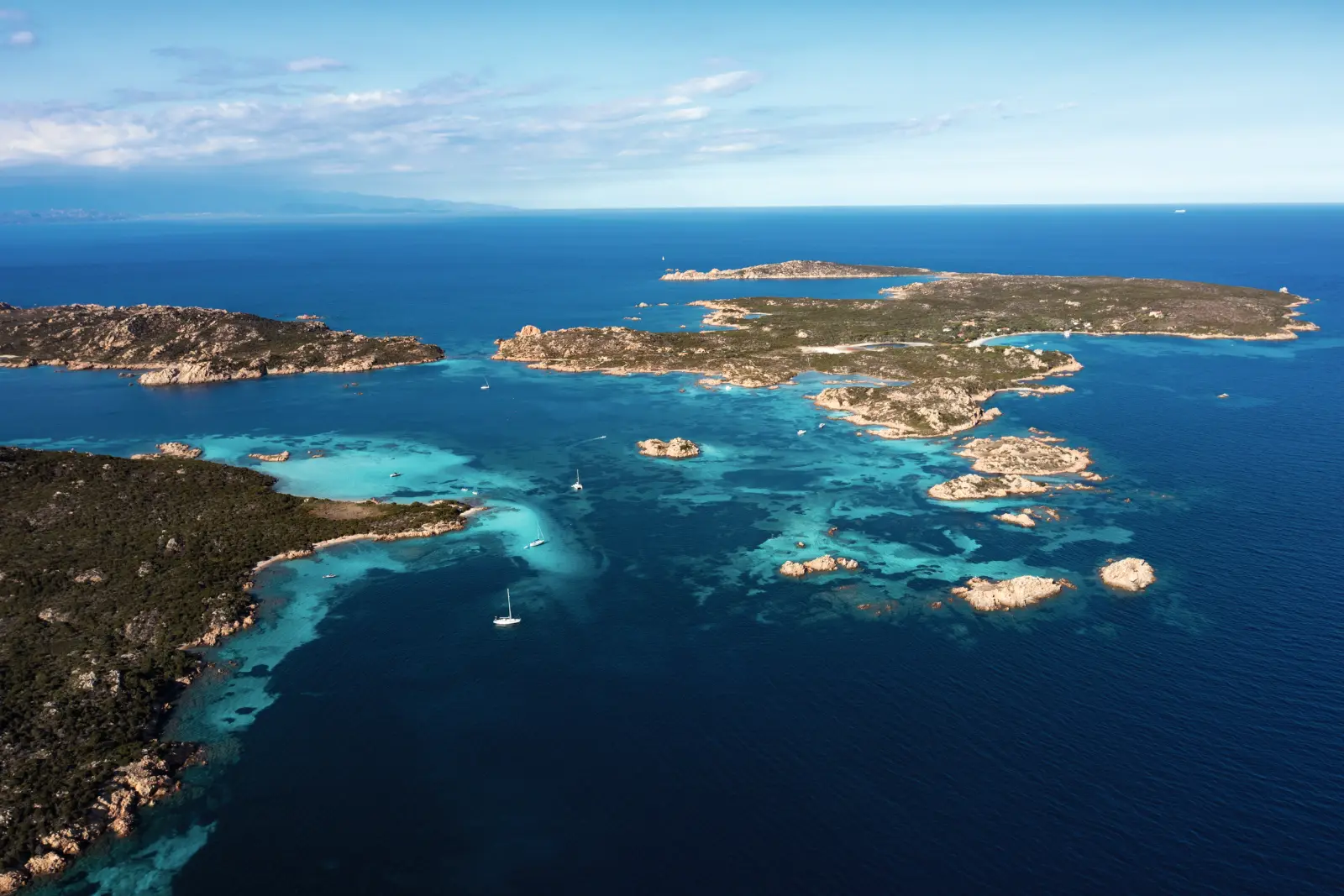 Vue aérienne d’un littoral avec des îles et une mer bleue.