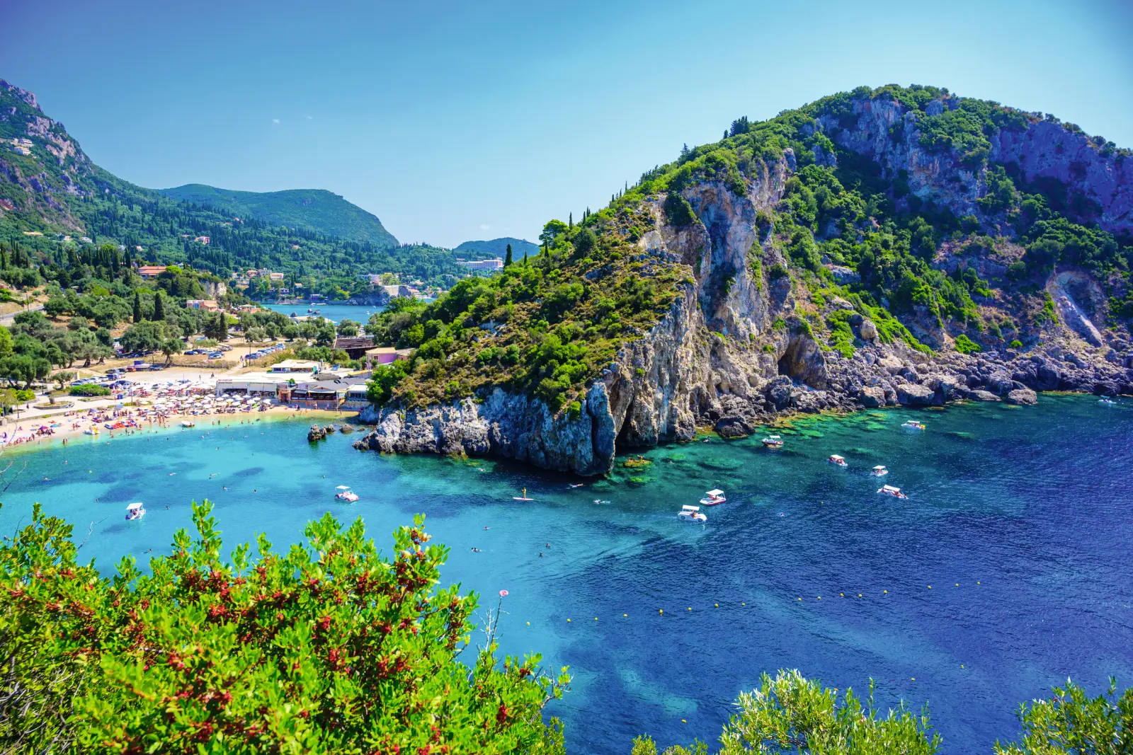 Coastline with turquoise water and green hills in the background.