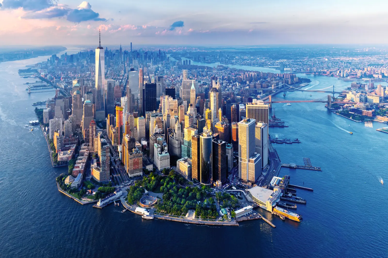 Aerial view of New York City with its skyline and rivers at sunset.