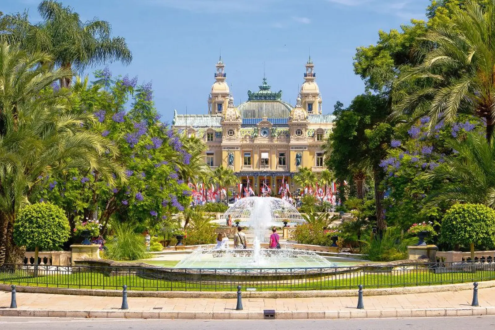 Bâtiment historique avec jardin et fontaine au premier plan.