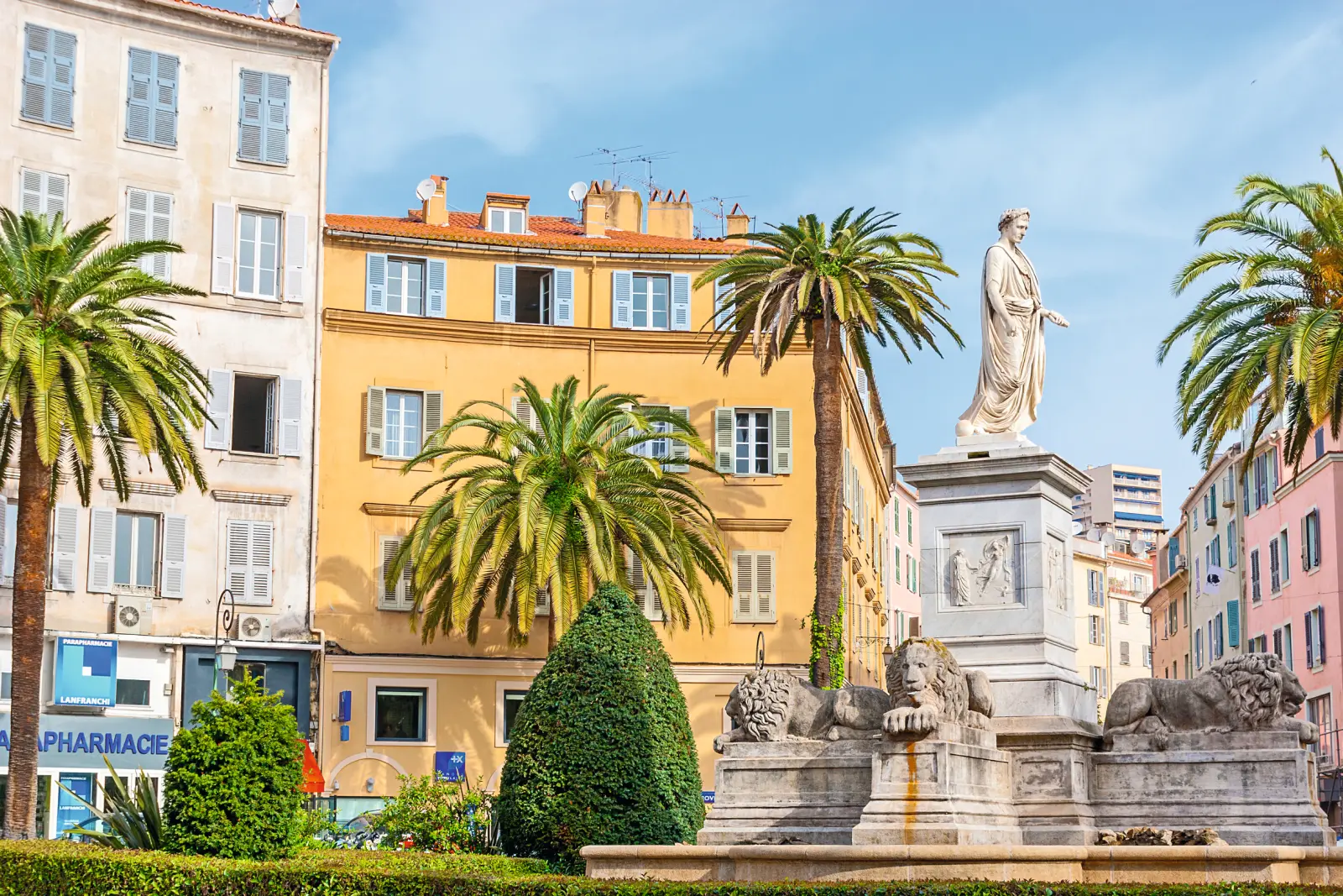 Statue de Napoléon à Ajaccio, en Corse, entourée de palmiers.