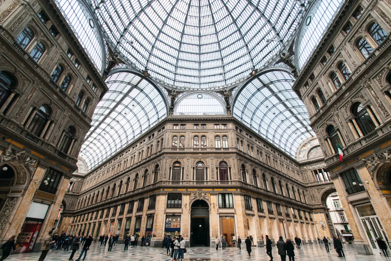 Veduta interna di un'elegante galleria commerciale con cupola in vetro e facciate storiche