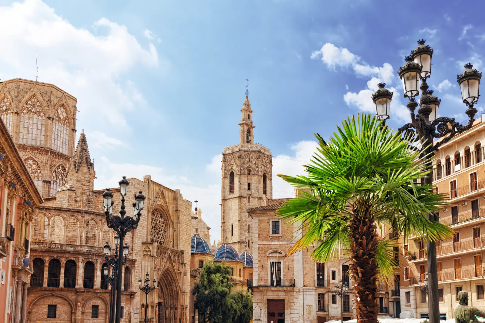 Historic buildings and palm trees under a blue sky.