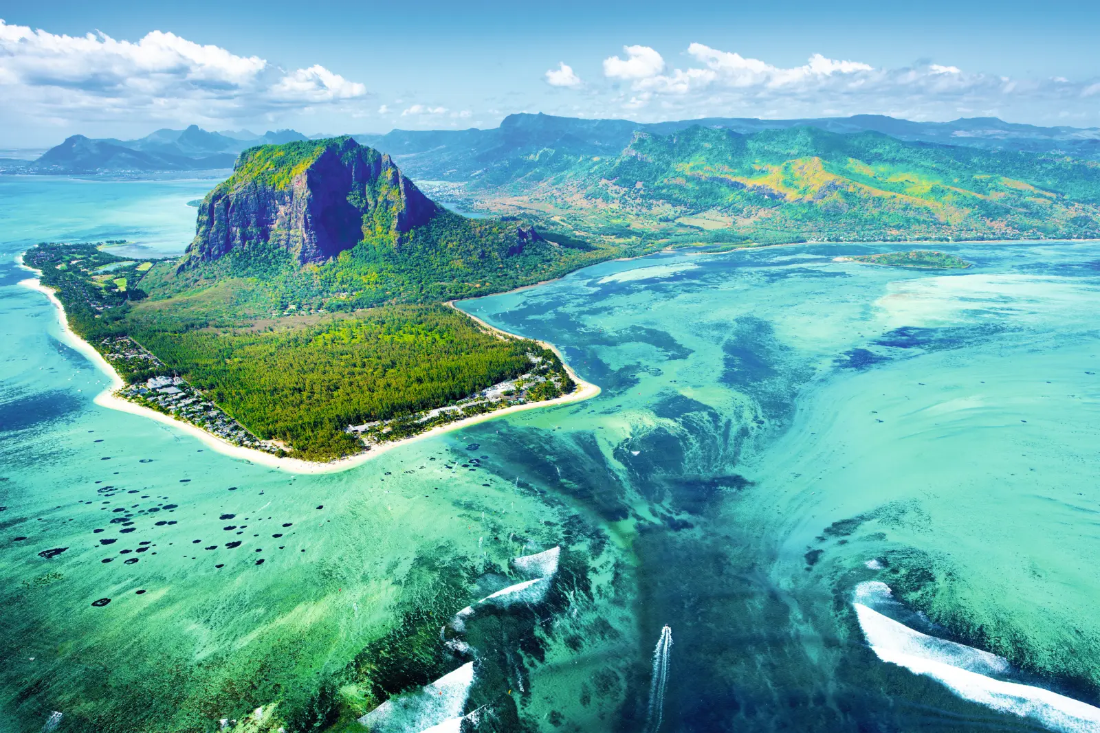 Aerial view of a tropical island with a beach and turquoise sea.