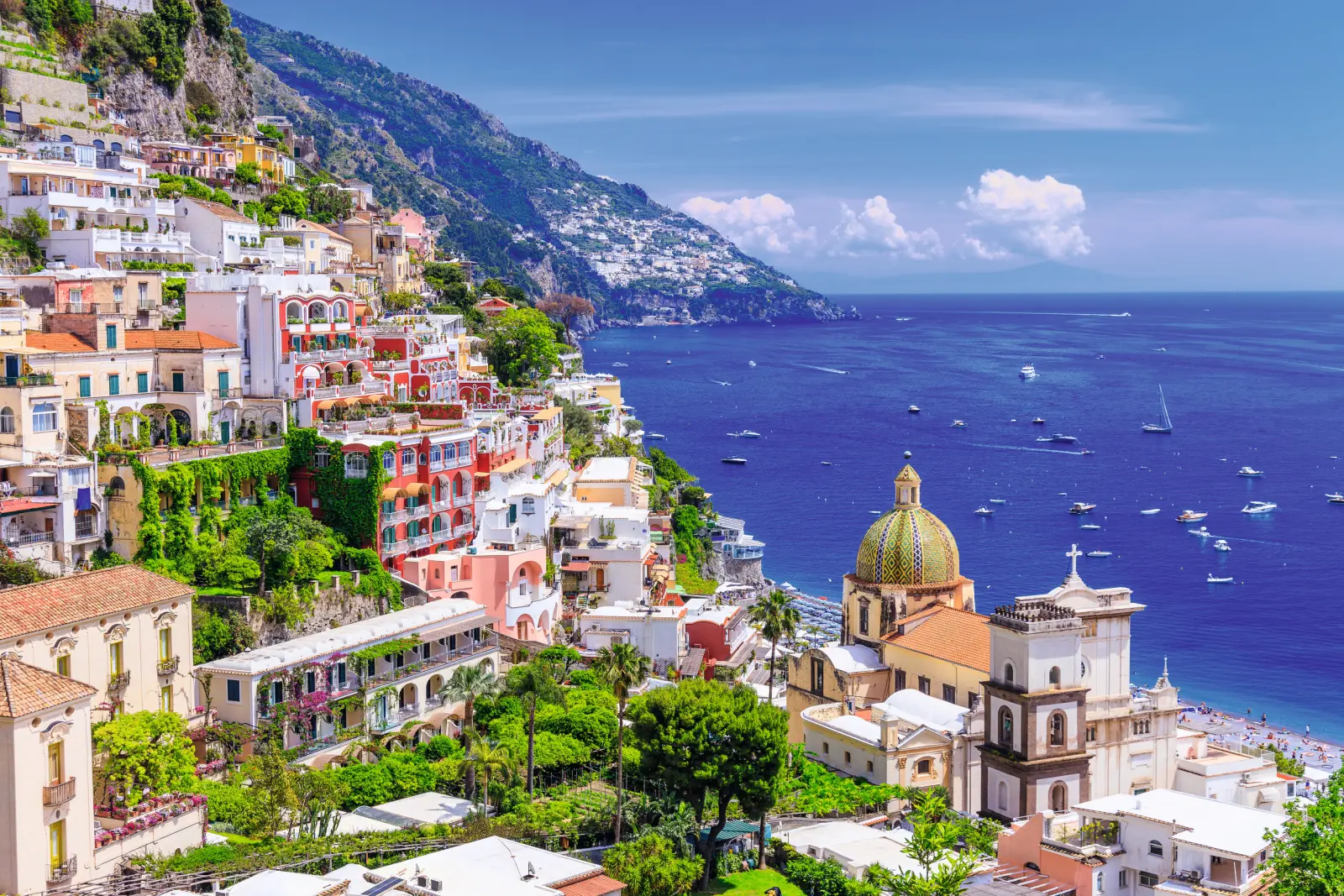 Coastal town with colourful buildings and a church by the blue sea.
