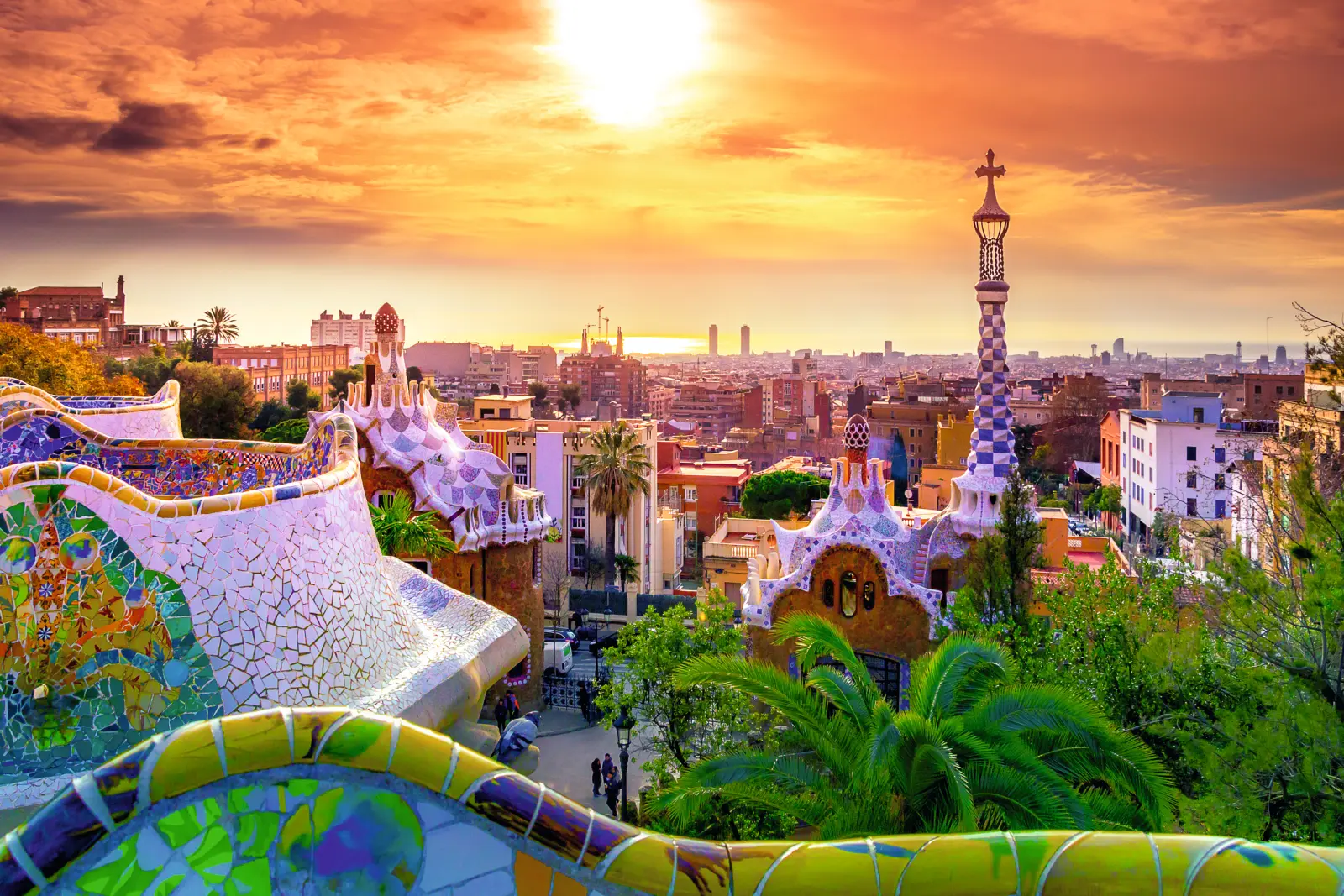 Sunset over Park Güell in Barcelona with a view of the city.