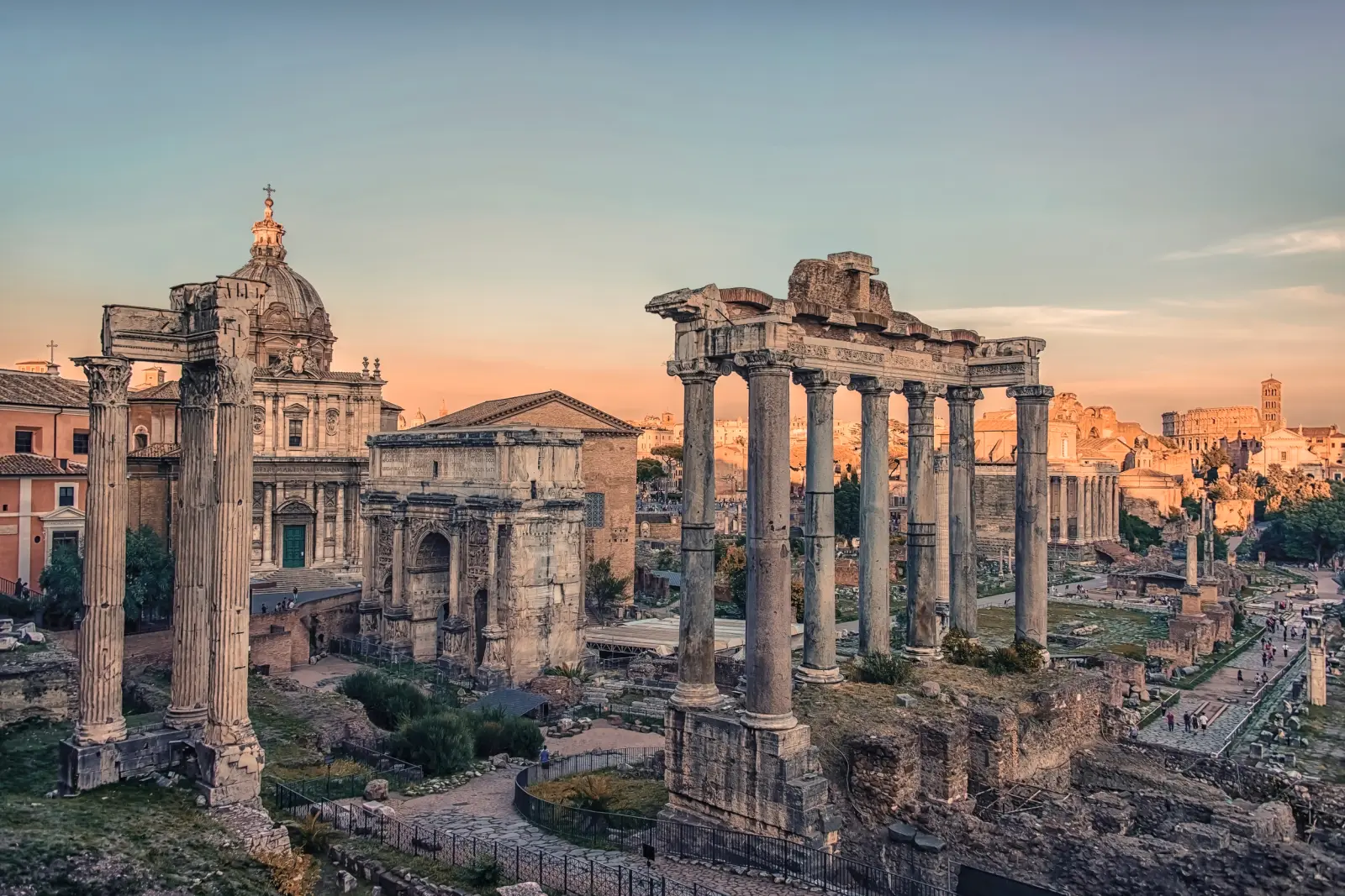 Il Foro Romano a Roma al tramonto, con antiche rovine e colonne in primo piano.