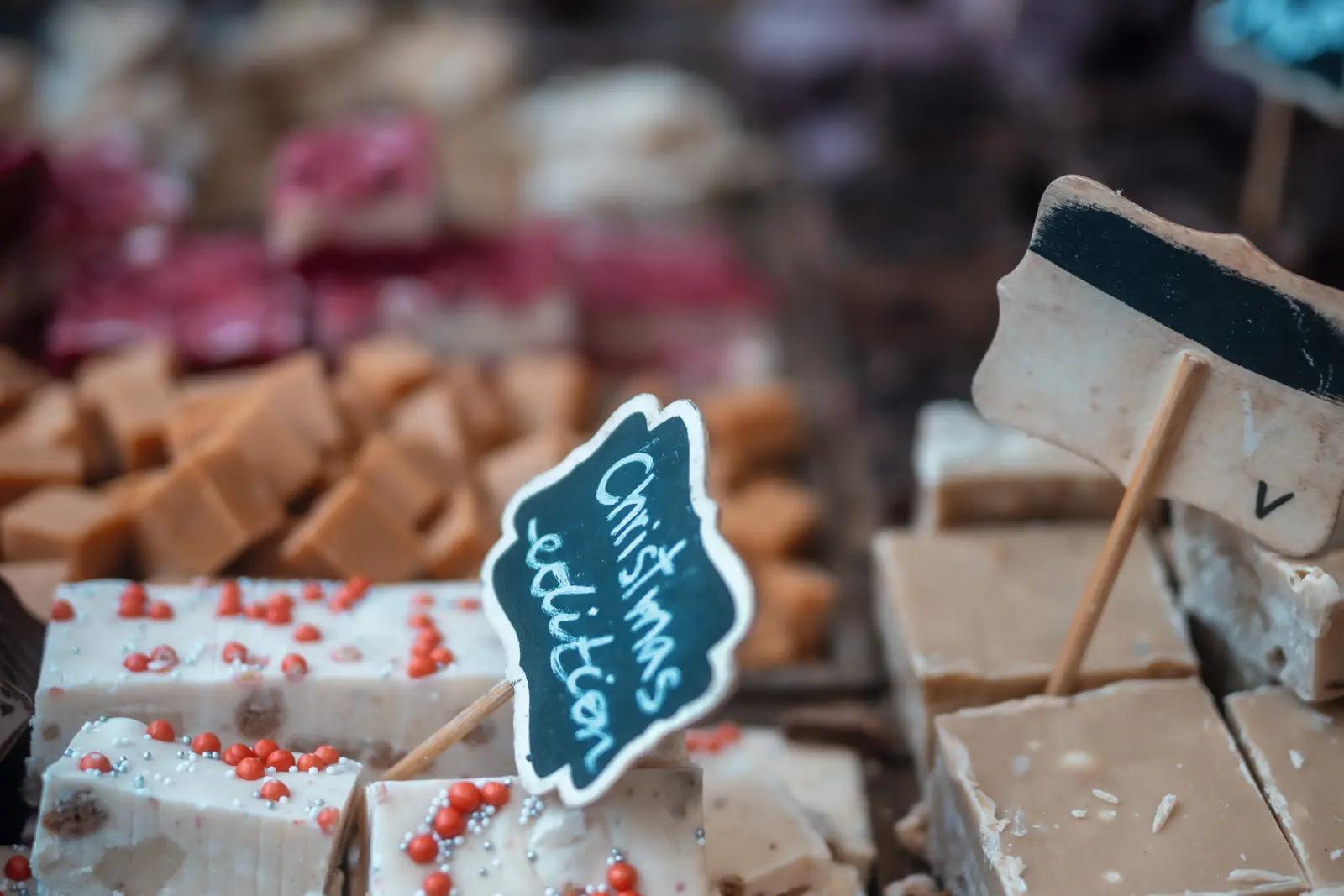 Chocolate stalls with various types and small signs at a festival.