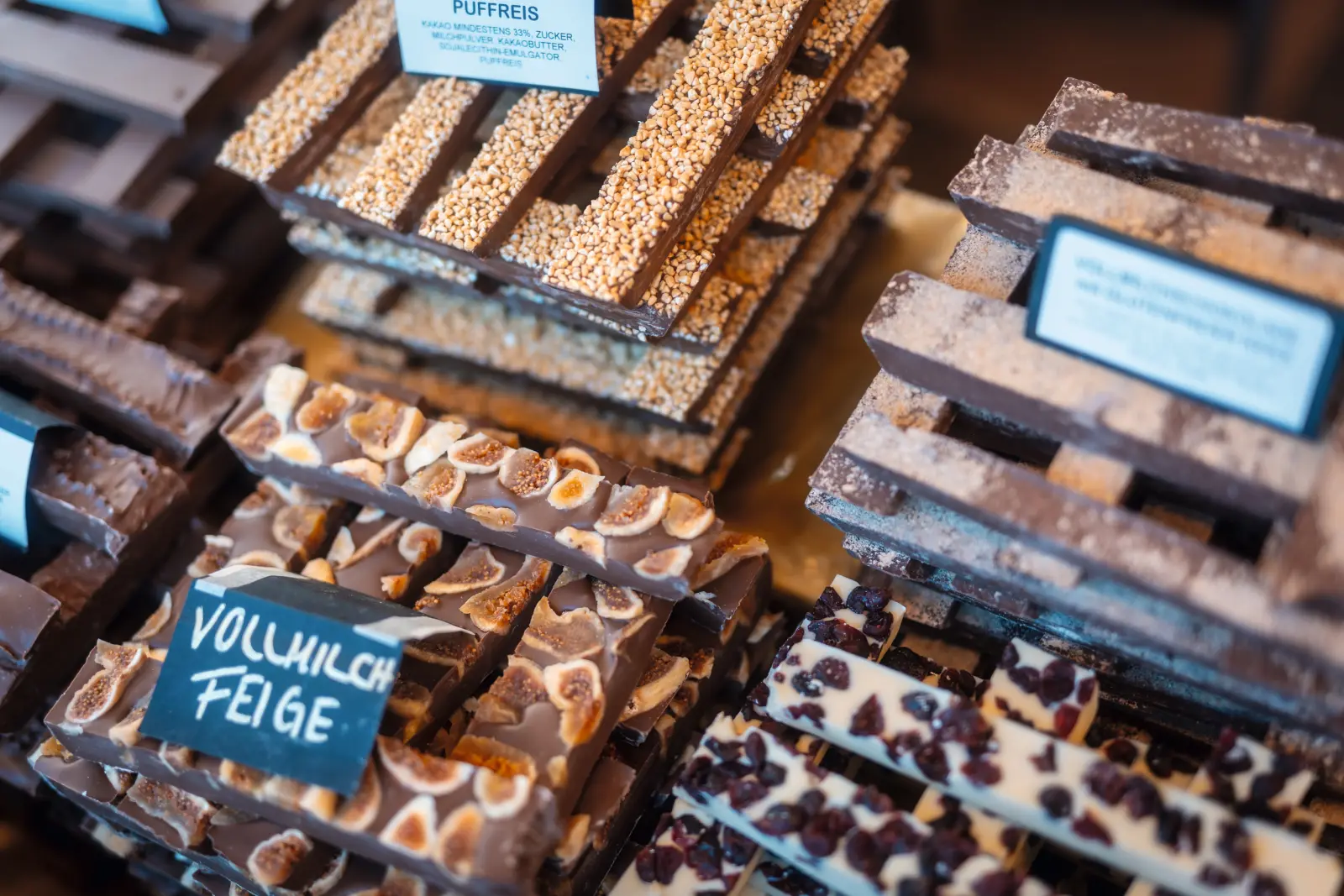Chocolate bars with various toppings on a market stall.