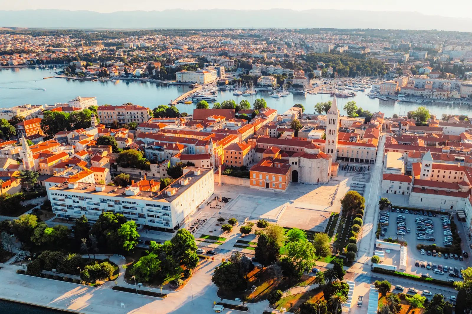 Luftaufnahme einer Küstenstadt mit historischen Gebäuden und Meeresblick.
