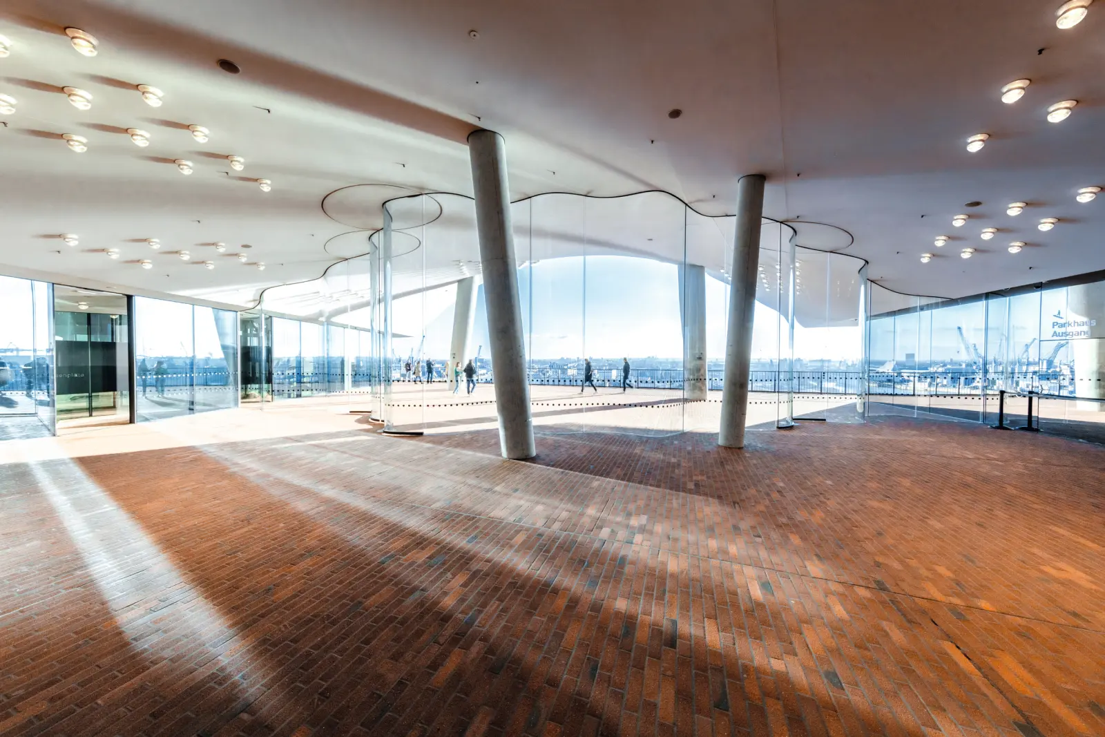 Interno della Elbphilharmonie con grandi finestre e pavimento rosso.