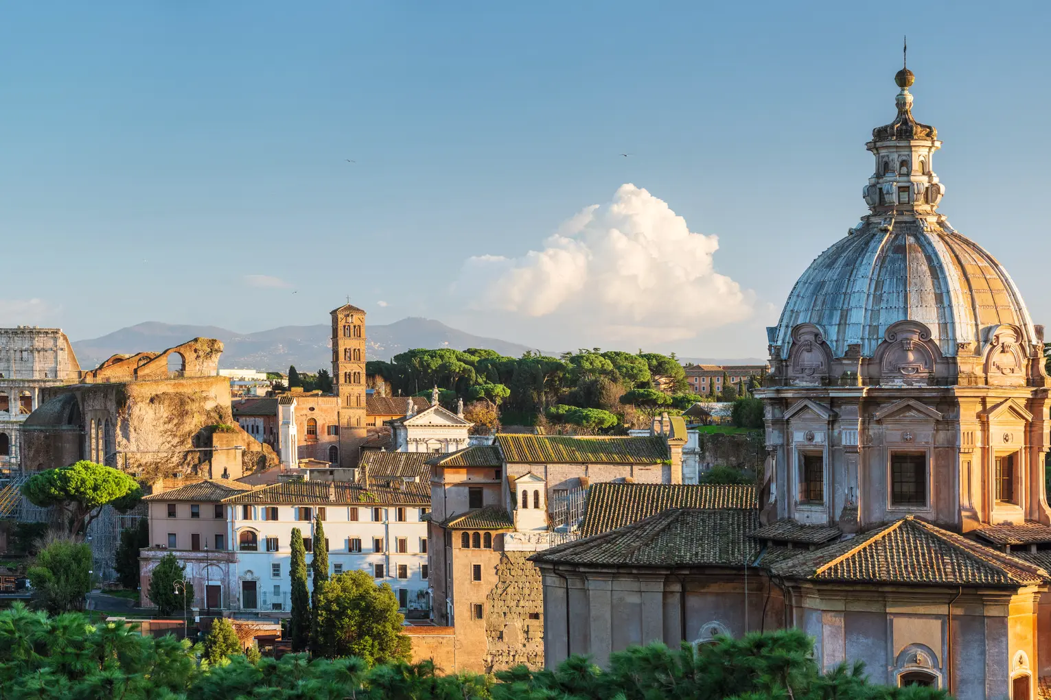 Panorama of the ancient ruins of Rome with the Colosseum in the background.
