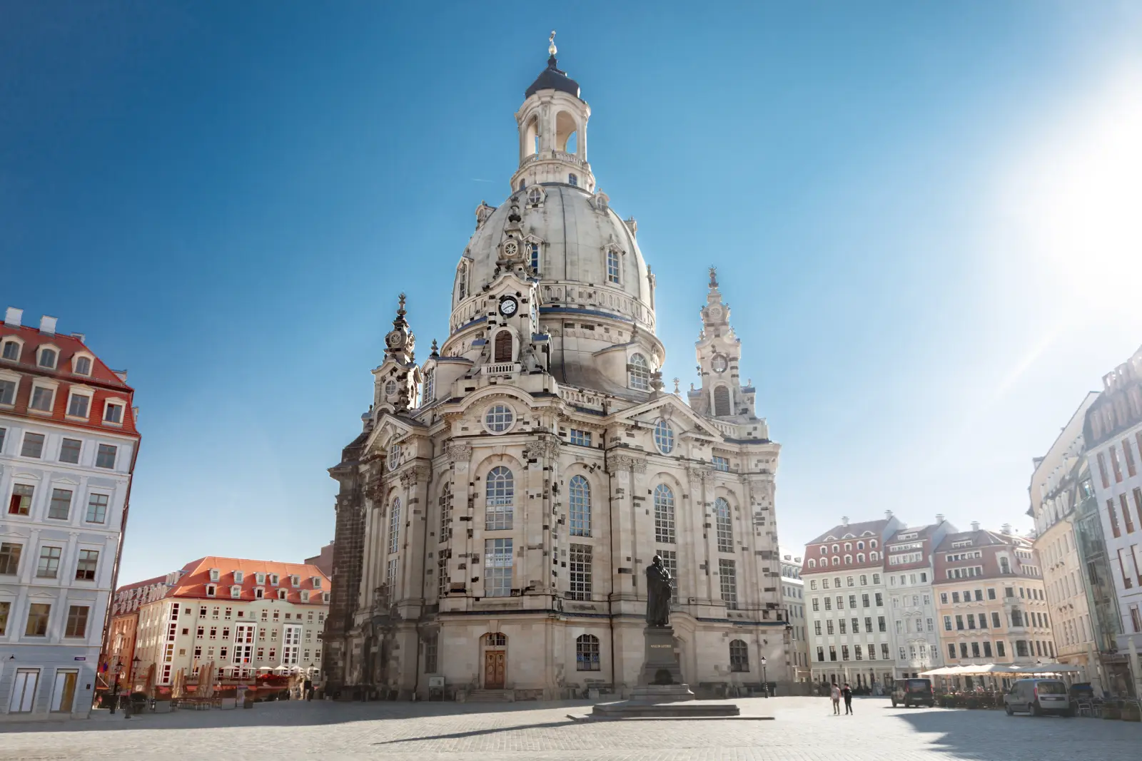 Frauenkirche de Dresde par temps ensoleillé, entourée de bâtiments historiques.