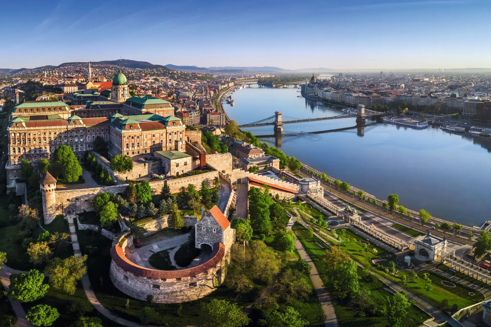 Veduta aerea di una città con fiume, ponte e architettura storica.