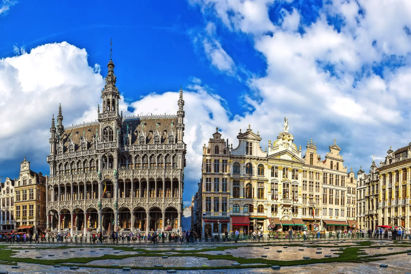 Edifici storici e cielo azzurro in una piazza animata.