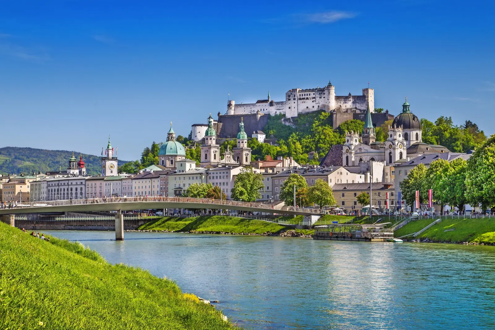 View of Salzburg with Hohensalzburg Fortress and the river in the foreground.
