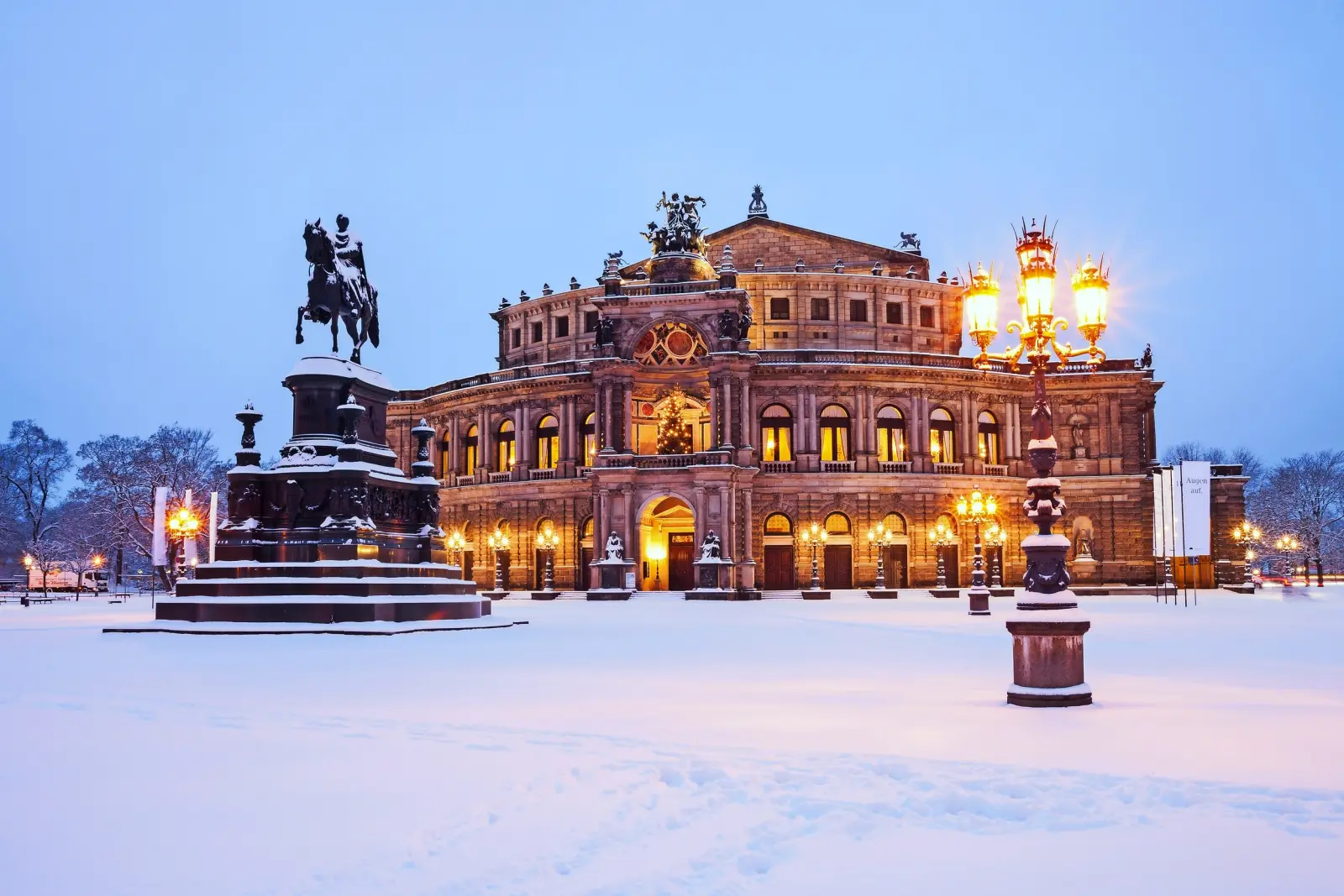 Opéra en hiver avec une place enneigée et une statue équestre.