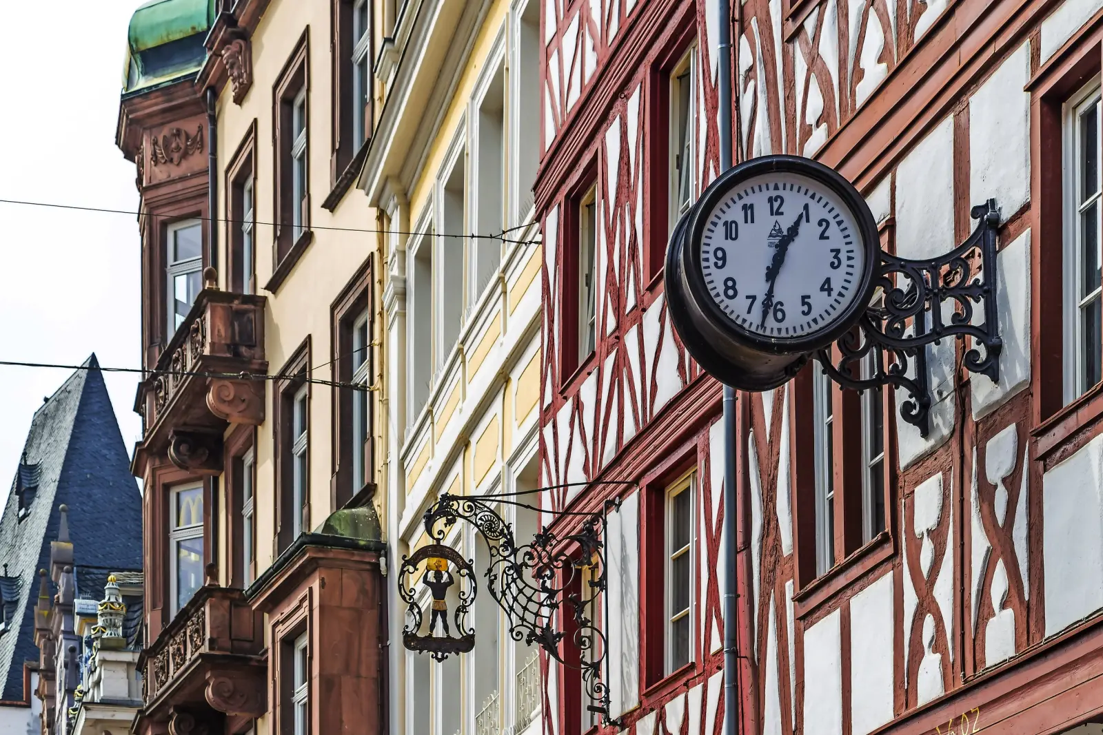 Case a graticcio con un orologio da parete analogico in un centro storico.