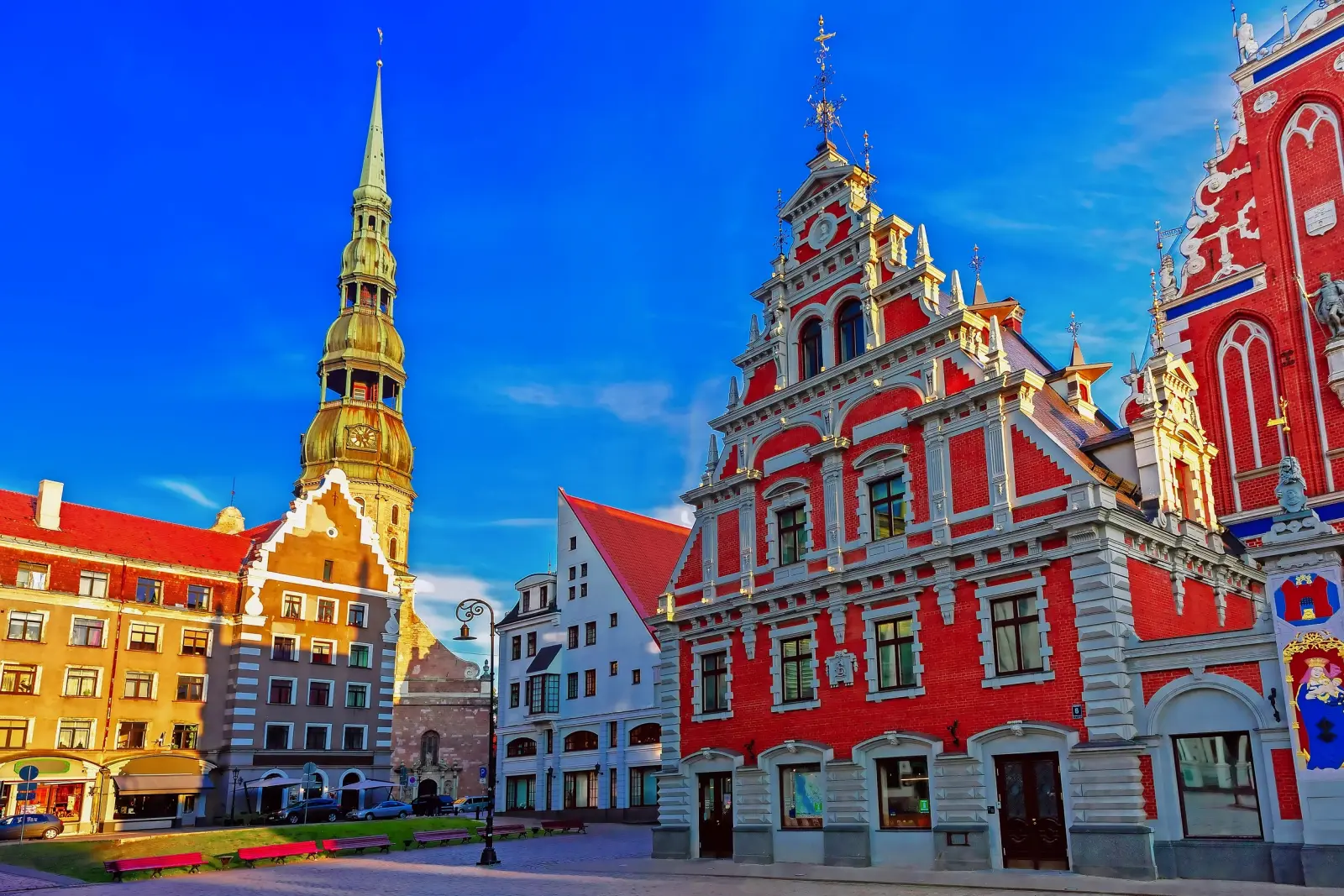 Historic buildings and a church tower under a blue sky in a European city.