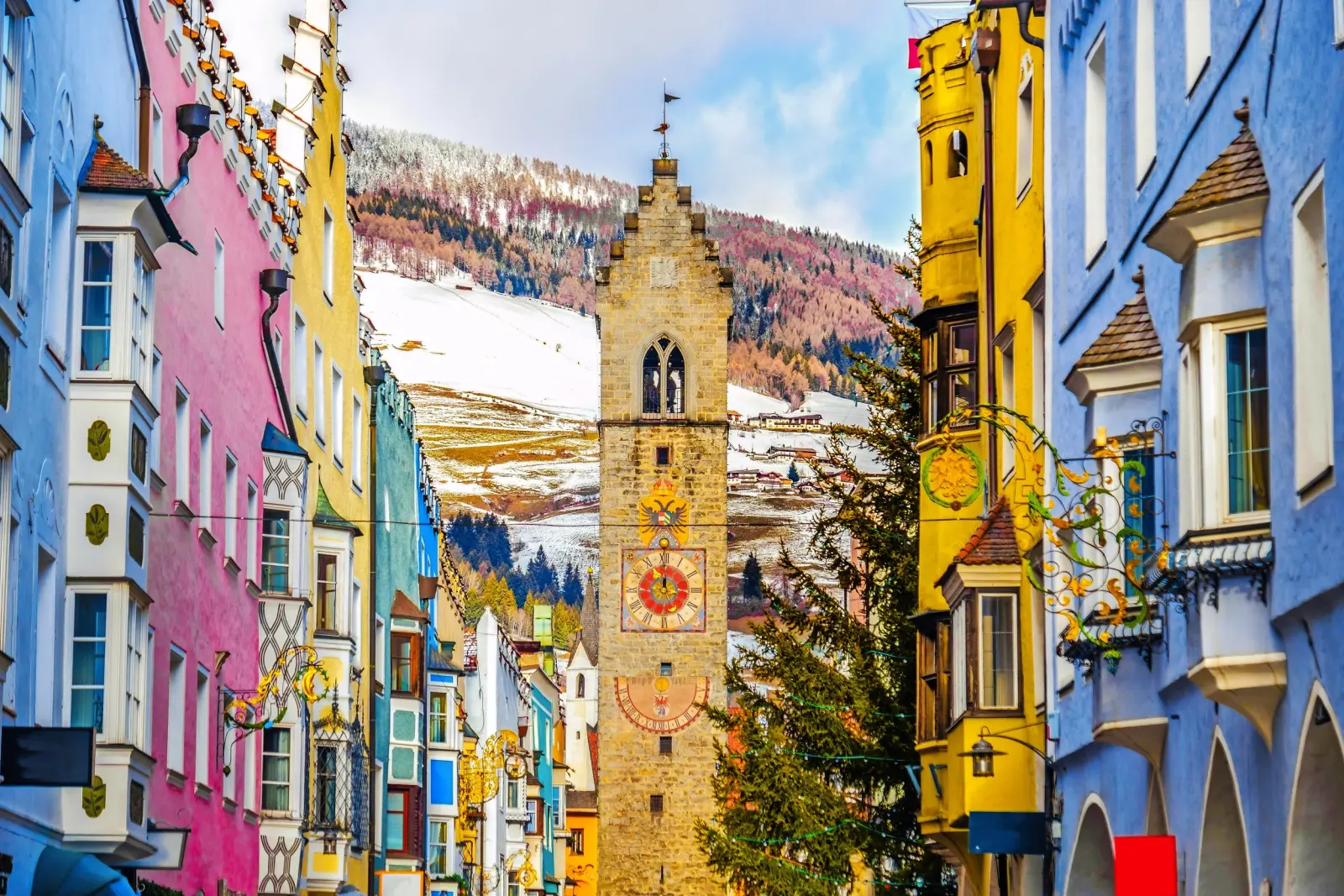Colourful house façade and tower in an Alpine town in winter.