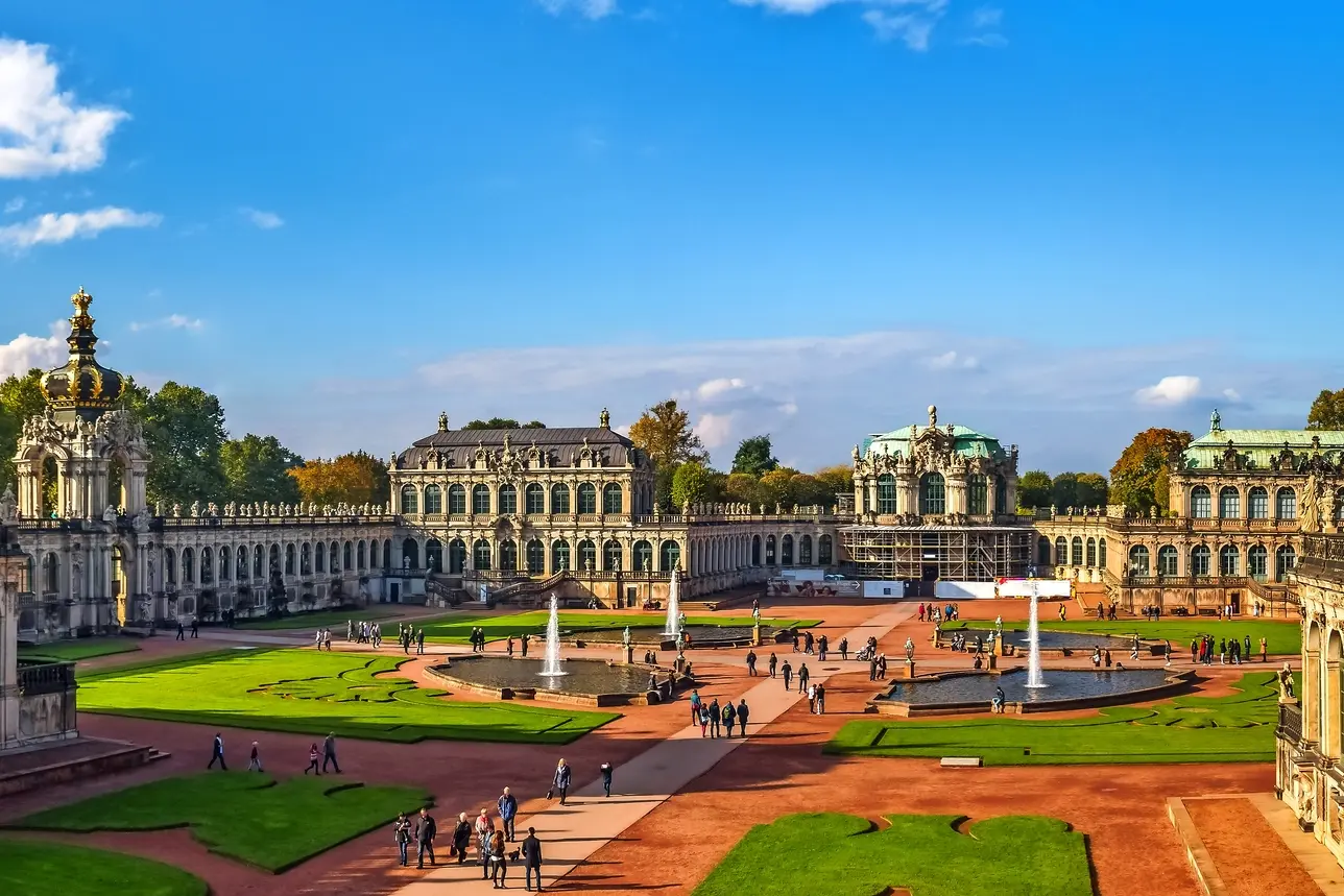 Architecture baroque du Zwinger de Dresde par temps ensoleillé, avec des personnes sur la place.